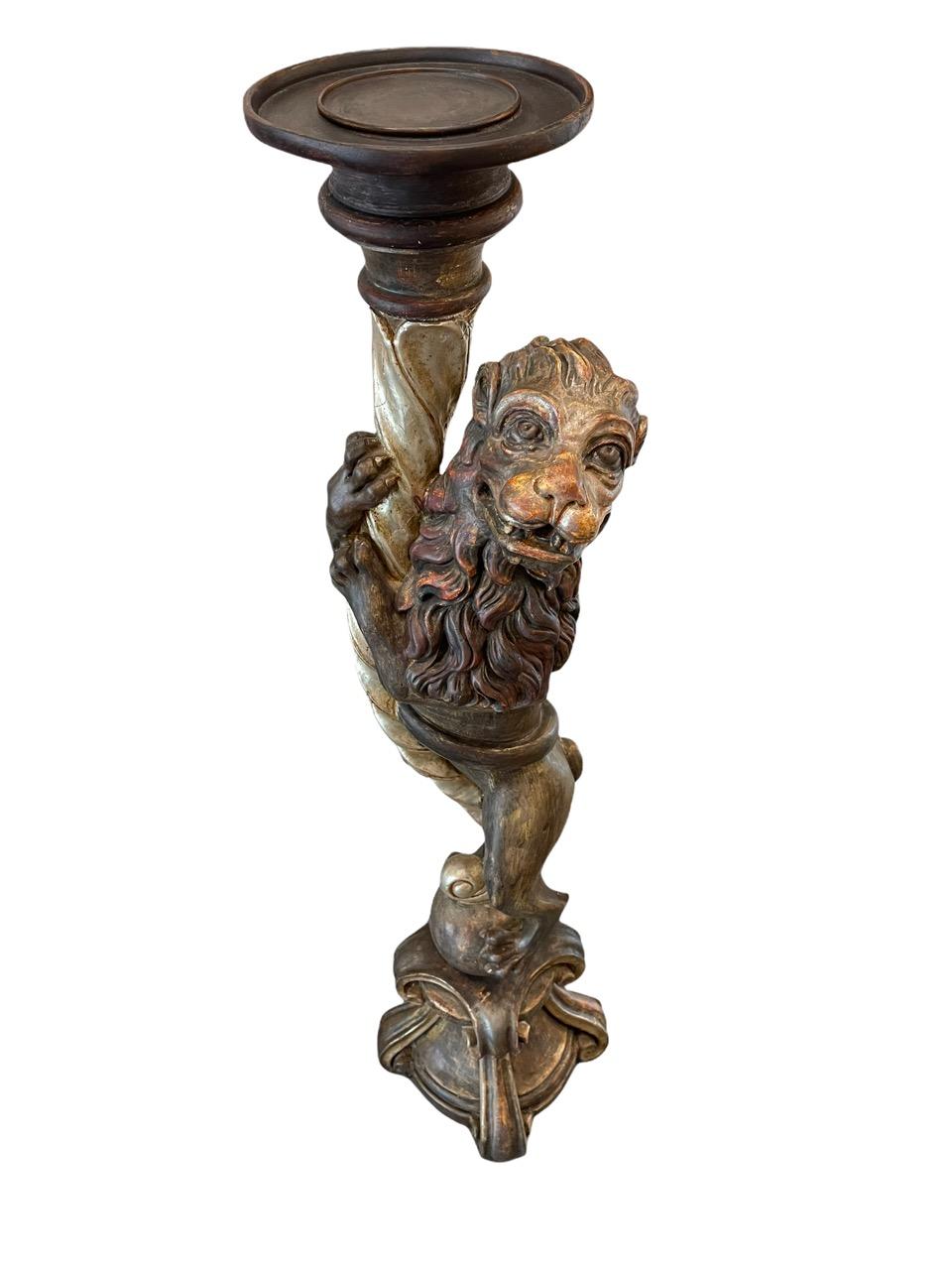 19th Century Russian Empire carved wood candle holder / plant stand. It has been modeled after a lion perched on a ball holding a white gold gilded torch. 
 