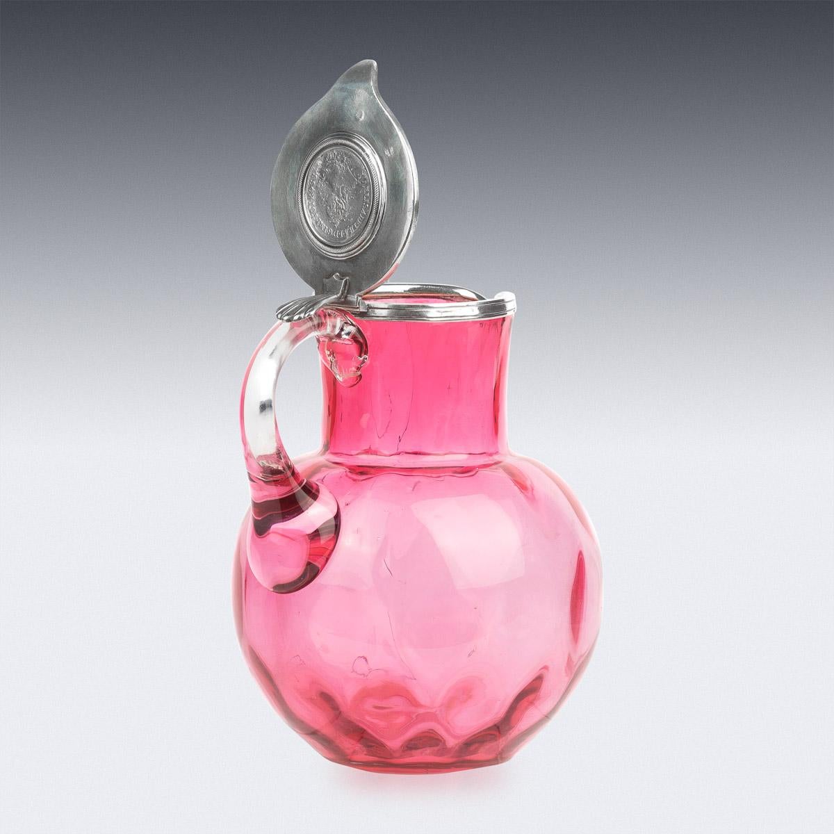 19th century Russian Faberge silver & blown glass jug, the plain pink glass body applied with a silver lid and set with a coin, the hinged lid applied with a shell shaped thumbpiece.

Hallmarked Russian silver 88 (915 standard), St-Petersburg,