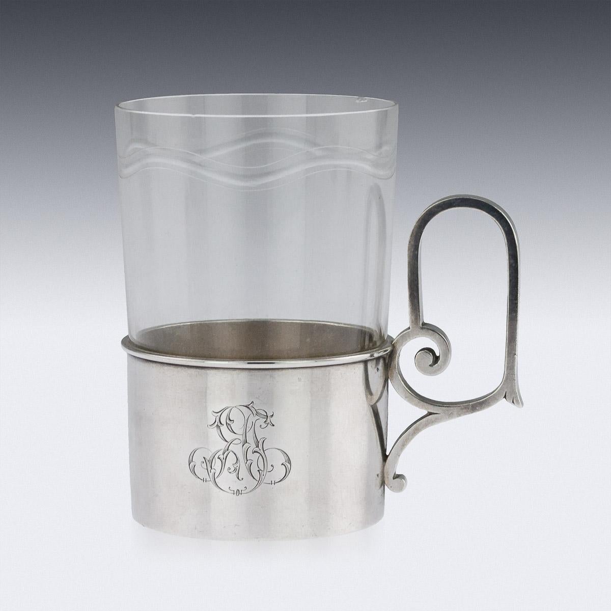 Antique 19th century Russian Faberge solid silver tea glass holder, the plain polished surface engraved with elaborate Cyrillic initials YaG, applied with a solid arching scroll handle, and fitted with faceted glass cup. Hallmarked silver 88 (915