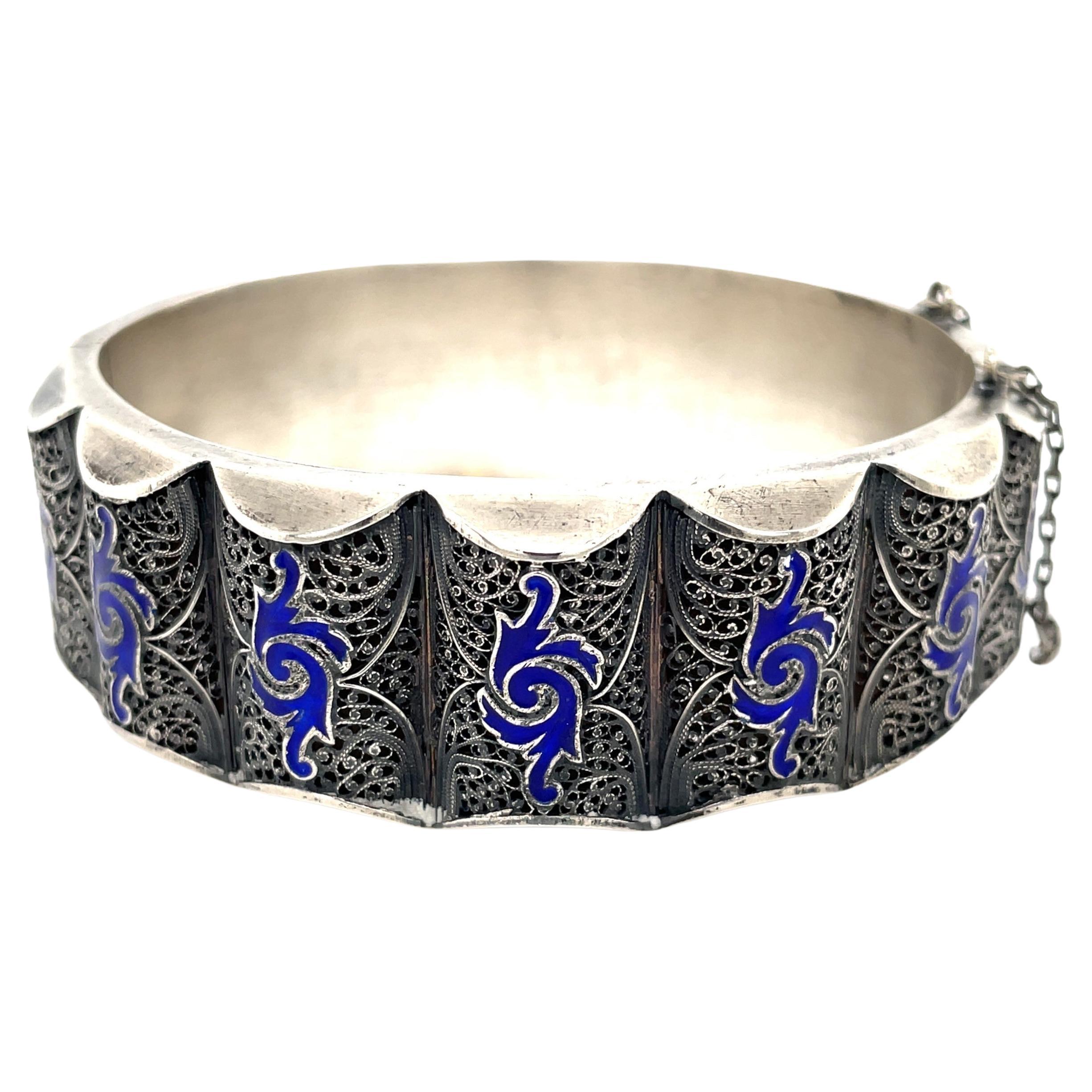 Wear a work of art with this early 19th century silver filigree cuff bracelet with vivid cobalt blue cloisonne enamel accents. Intricate hand crafted .900 silver filigree presents around this unique 2-1/2 inch bangle bracelet. The width is