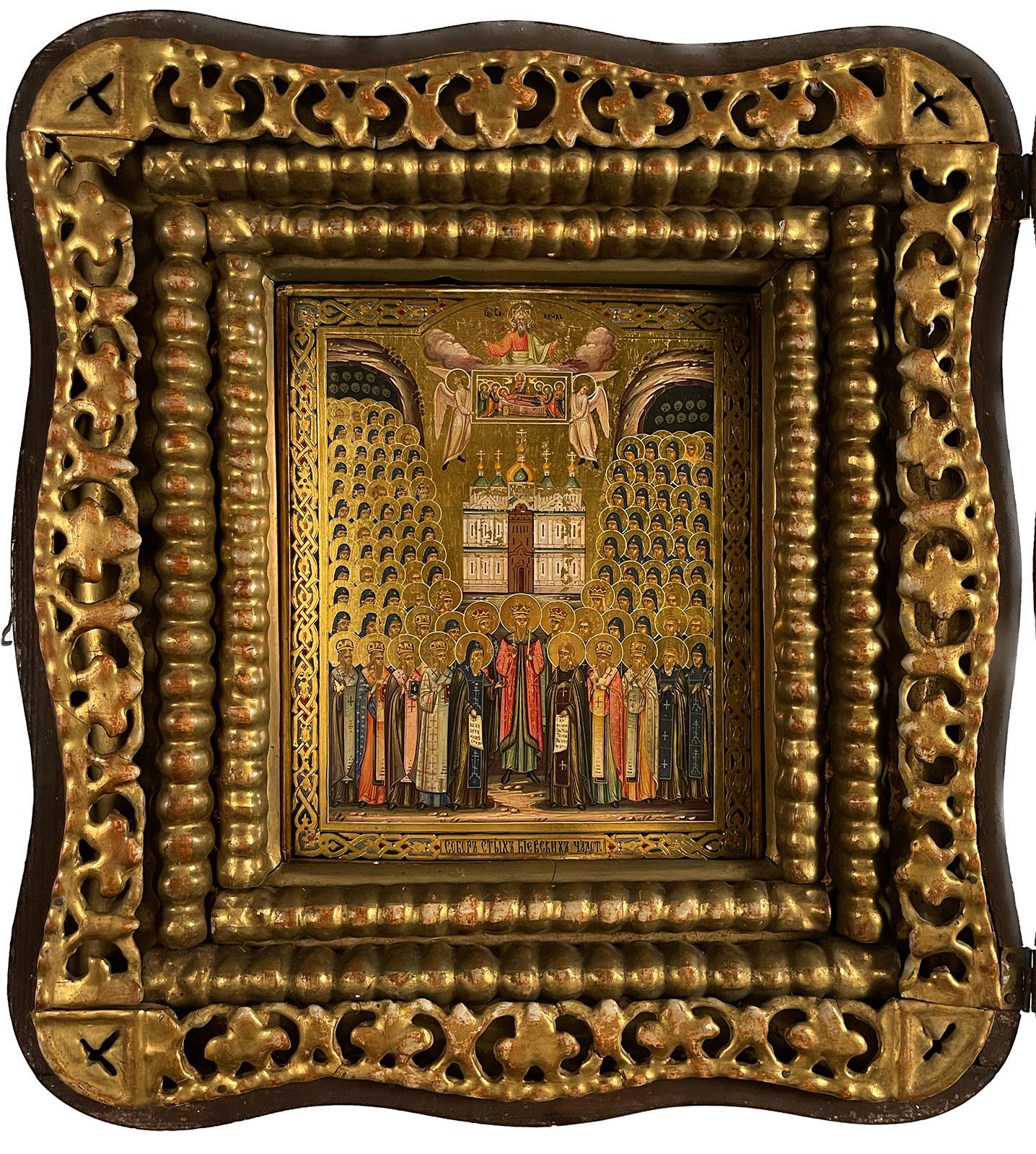 A 19th century Russian Icon with giltwood and Cyrillic text enclosed in a shadowbox frame. The bottom translates to 