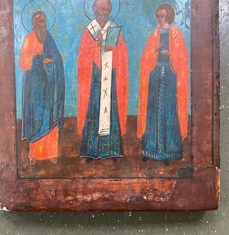 19th century Russian Icon of Saint Nicholas, likely first half 19th century, with I believe egg tempera on gessoed wooden panel, depicting Christ in a hemi-circle reserve in the clouds at top of panel, looking down and blessing Saints Simeon,