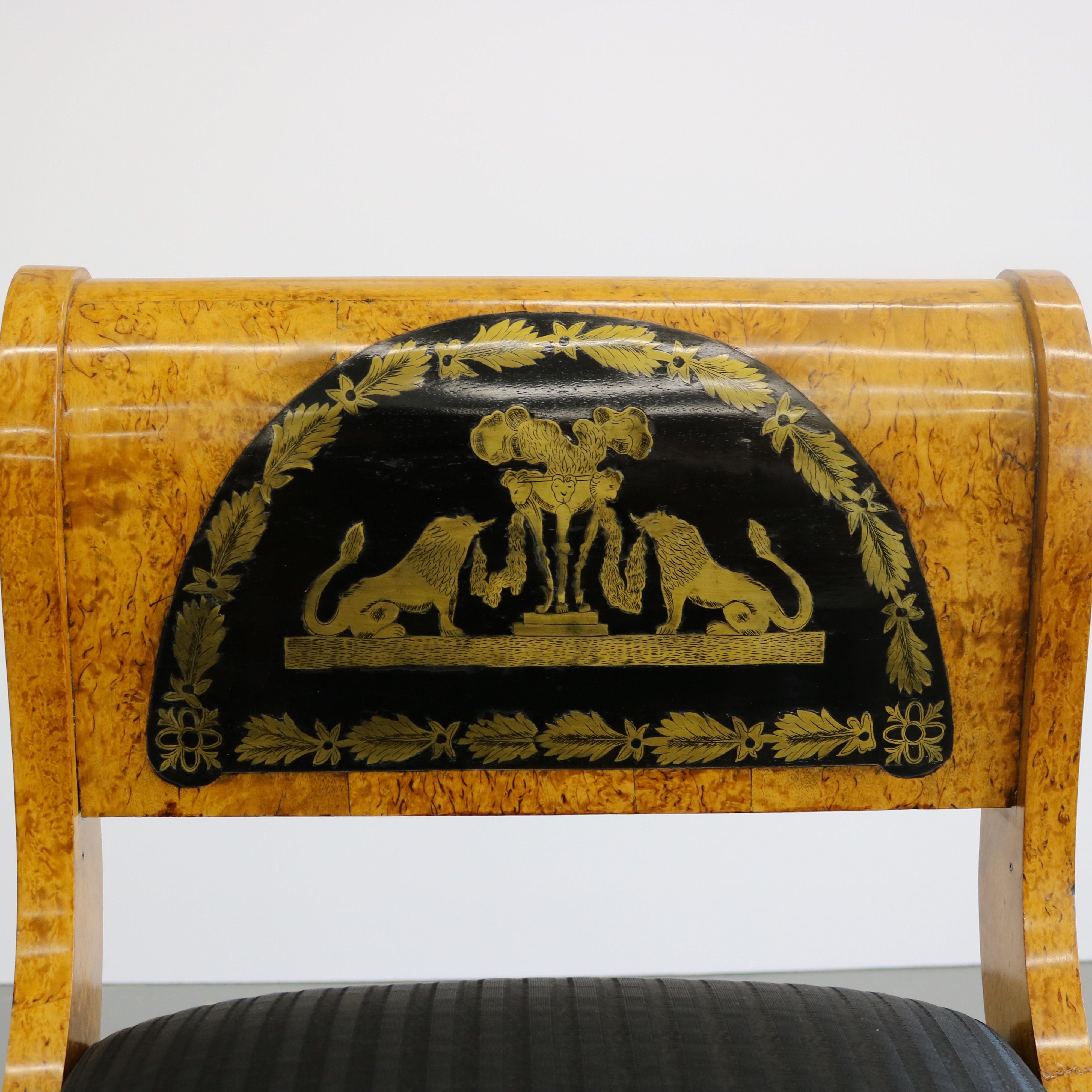 A handsome Russian Neoclassical Karelian birchwood and ebonized fruitwood seat bench with fine figurative Boulle brass work from Russia circa 1850. Each of the scrolled arms feature a half moon arch of reflective ebony like timber inlaid with a