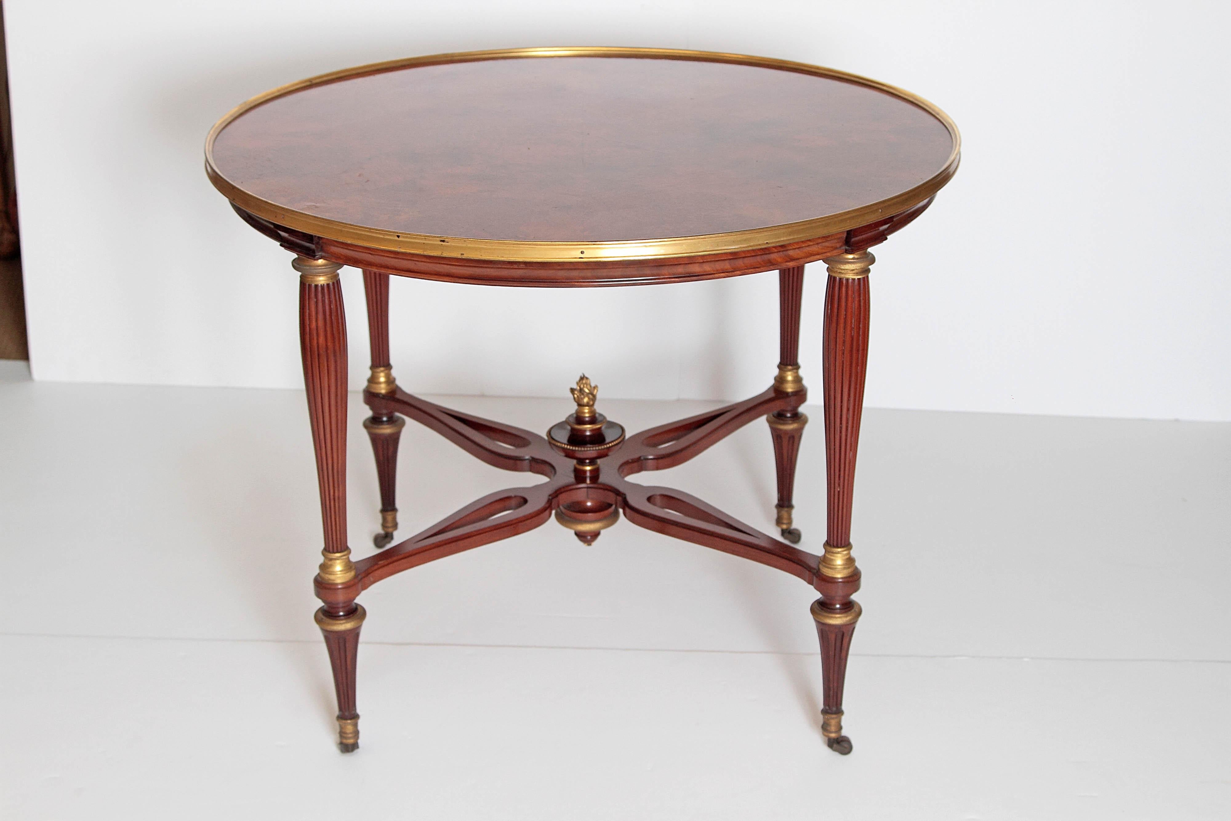 A Russian center table, neoclassical, with book-matched burled walnut top (laid out like pie pieces / triangular sections) with gilt bronze edge / border, beautifully turned / shaped and reeded legs with well defined joints, saltire stretcher with