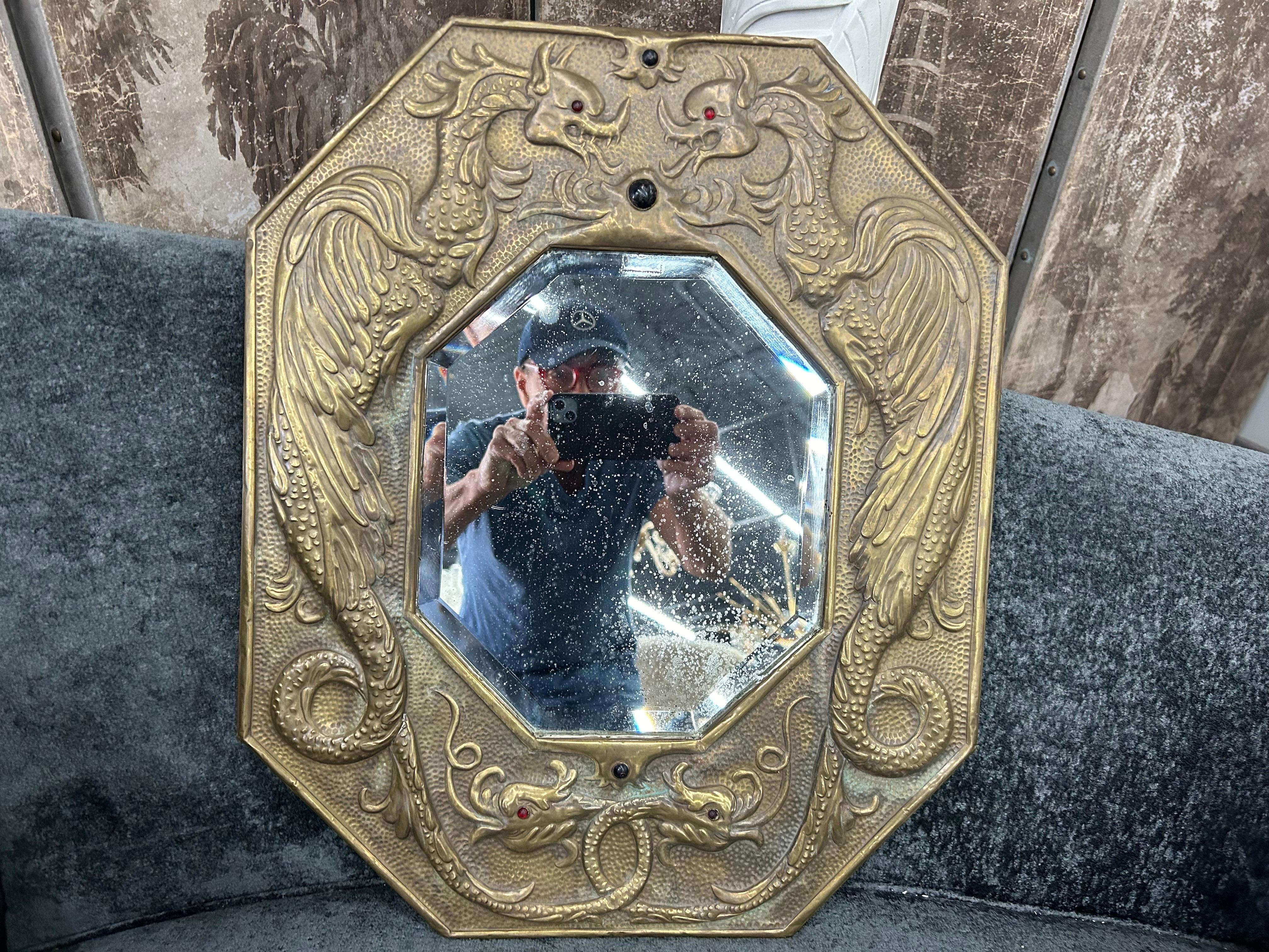 Miroir russe en laiton du XIXe siècle.
Ce miroir biseauté octogonal en laiton russe repoussé (martelé à la main) avec des inserts colorés conviendrait parfaitement à une salle d'eau, un couloir ou un dressing. Le miroir central biseauté présente de