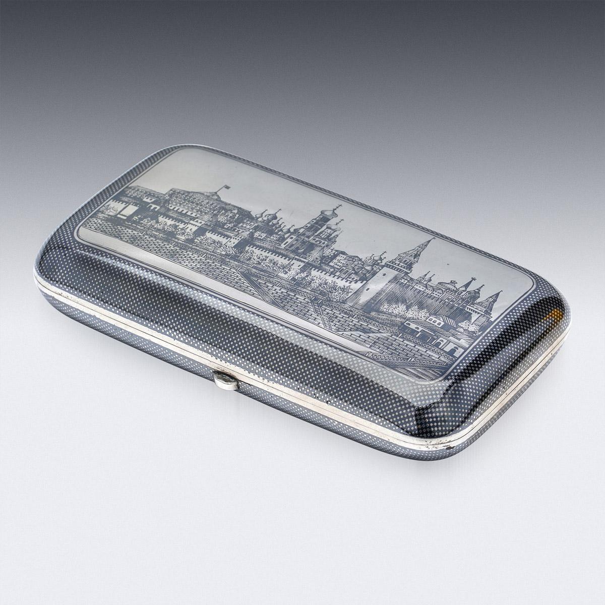 19th Century Russian silver & niello enamel large cigarette case, parcel gilt, each side decorated with a niello enamel decoration, the cover depicting view of the Kremlin, reverse with a vacant cartoosh for the owners initials, the sprung hinge is