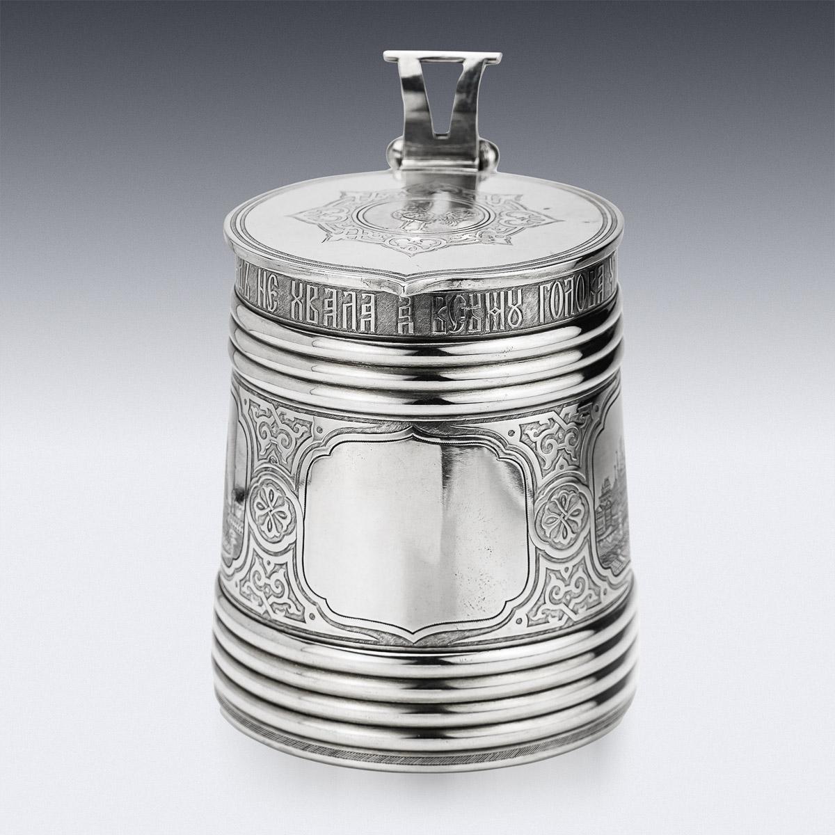 Antique 19th Century Imperial Russian solid silver lidded tankard, parcel gilt, of traditional form, C-shaped handle terminating with a large thumb-piece, engraved depicting famous Moscow landmarks, the sides and top of the lid chased with foliate