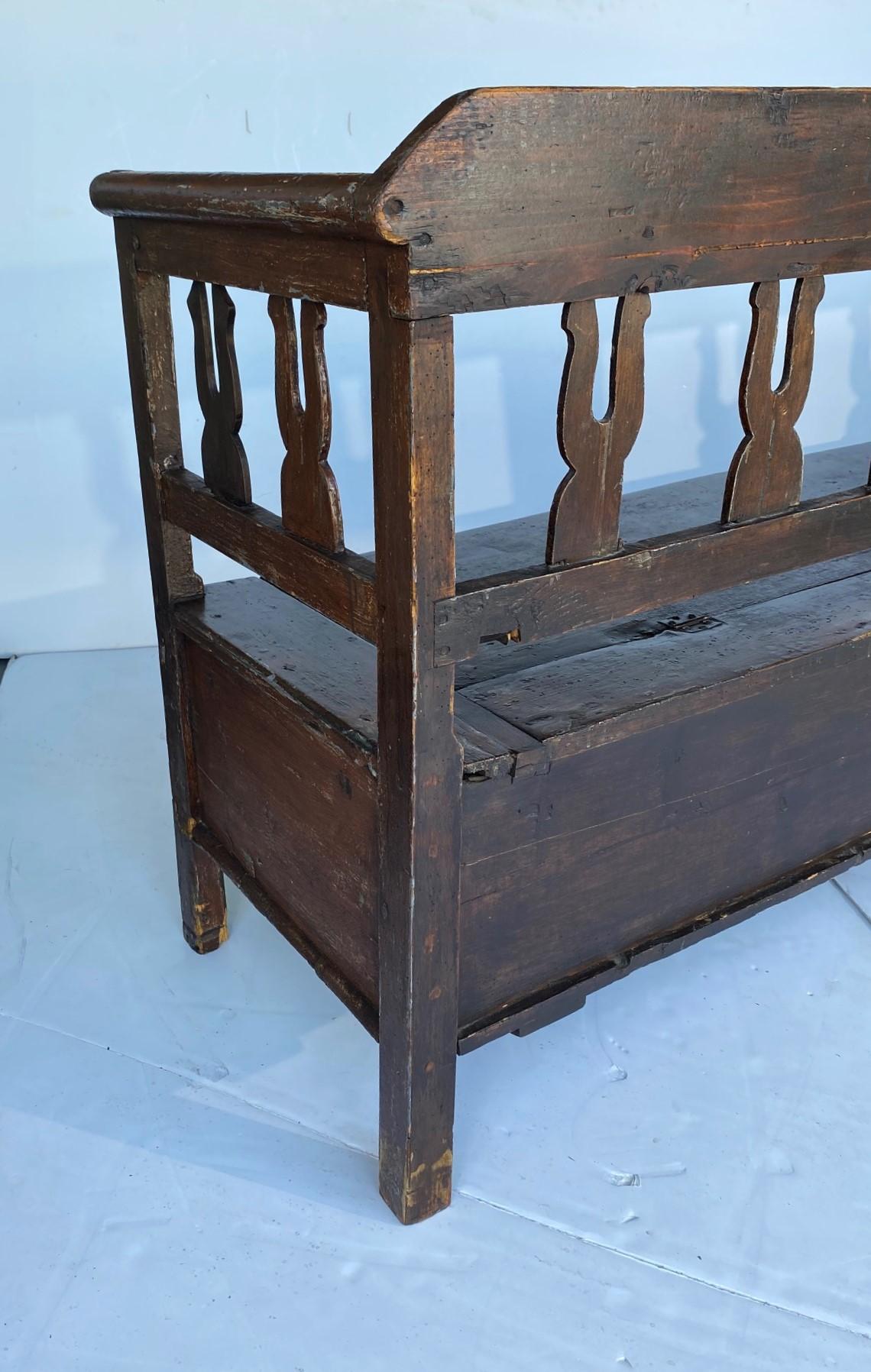 19th-century European rustic bench with storage.