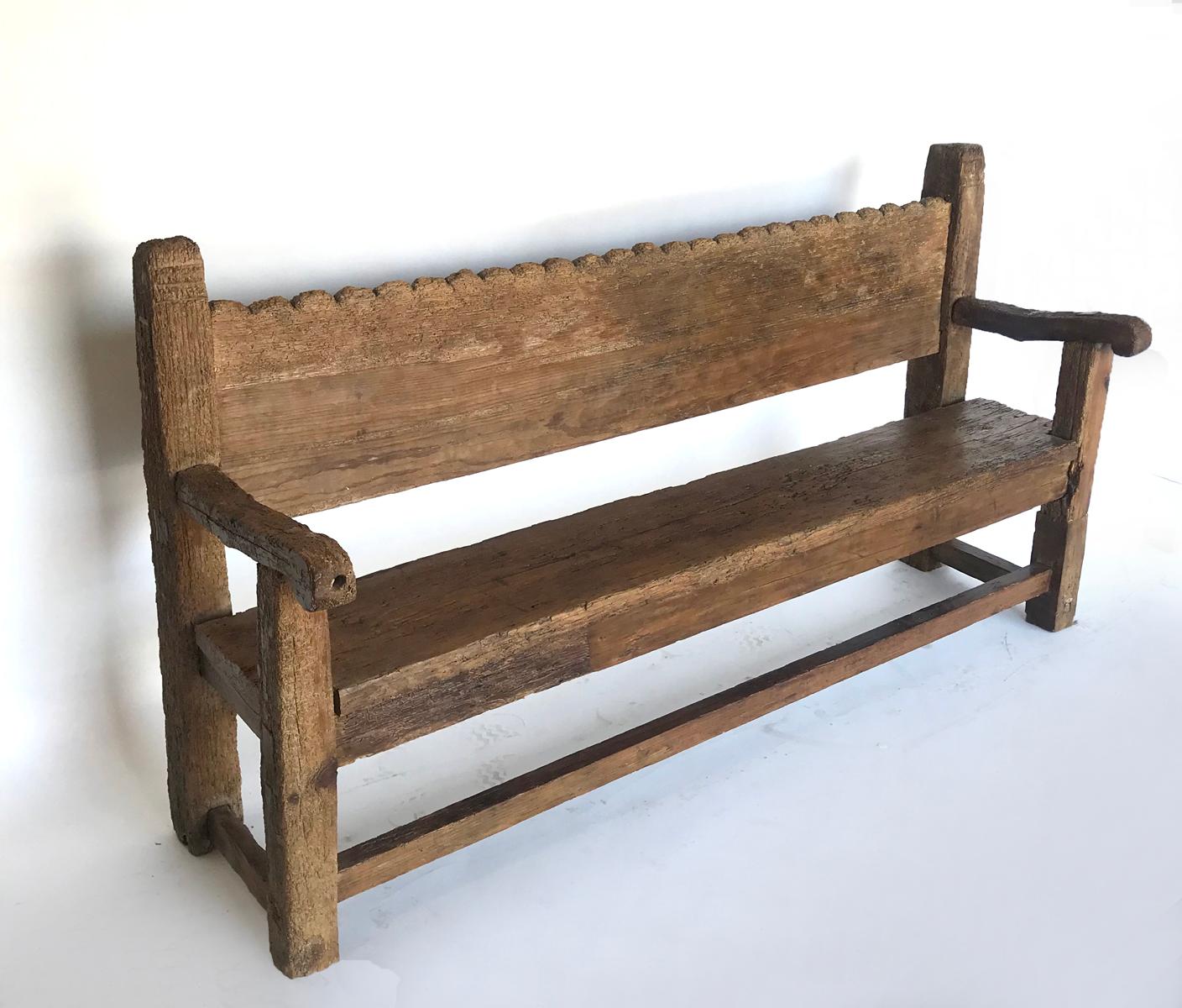 All original, very rustic Chajul bench from the highlands of Guatemala. Mortise and tenon construction. Seat and back both consists of wide boards that have been traditionally hand hewn using a machete. Worn scallops along the back. Weathered and