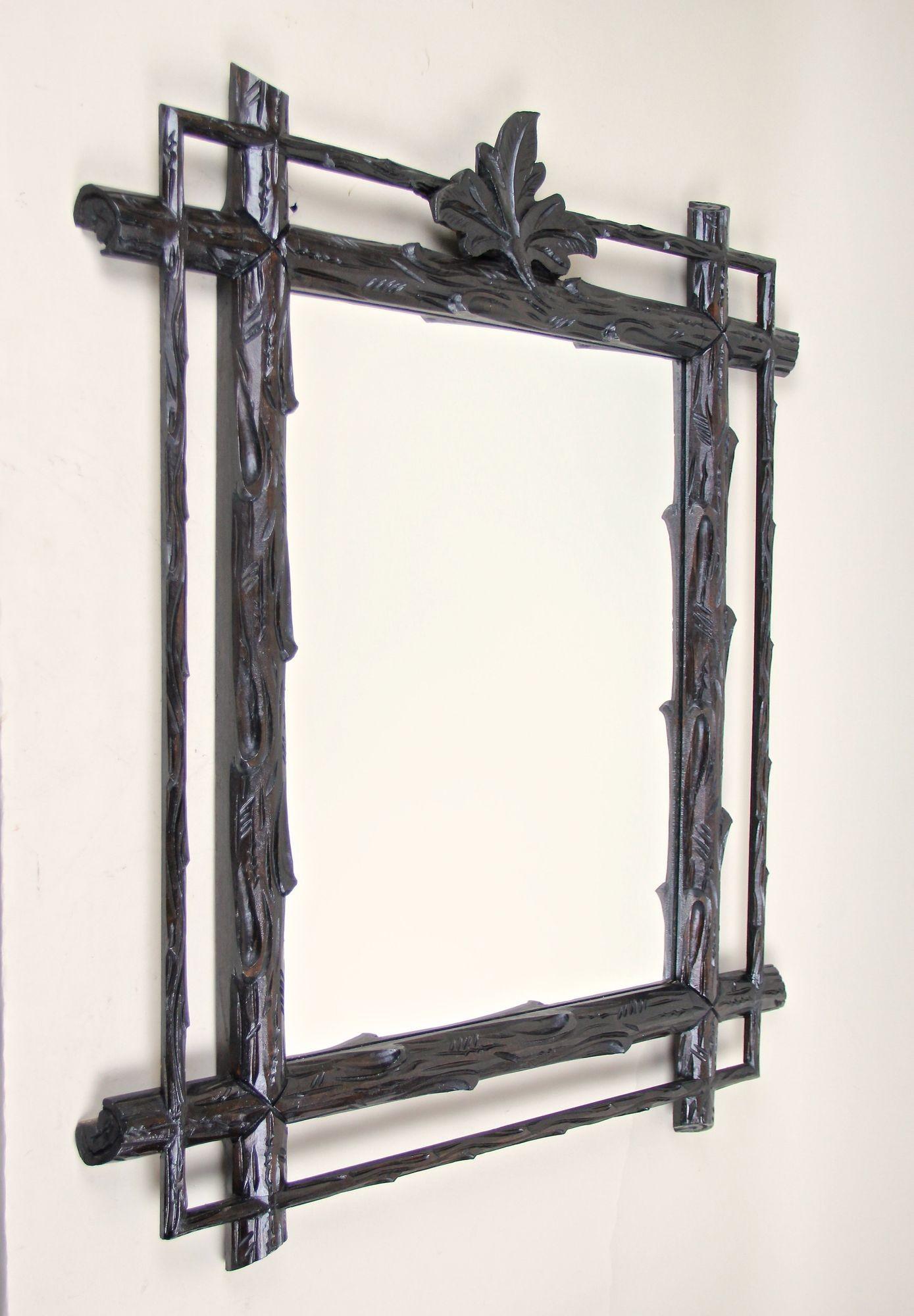 Straordinario specchio rustico da parete Black Forest della fine del XIX secolo in Austria. Elaboratamente intagliato a mano in pregiato legno di tiglio, questo eccezionale specchio antico presenta un sorprendente design rurale: una cornice