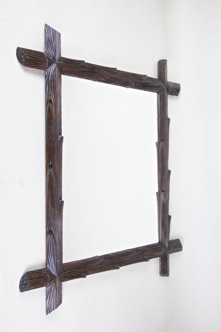 Magnifique miroir mural de la fin du 19e siècle, provenant de la Forêt Noire en Autriche vers 1890. Ce grand miroir rustique en bois a été minutieusement sculpté à la main dans du tilleul, à la manière des branches d'arbre, et impressionne par ses