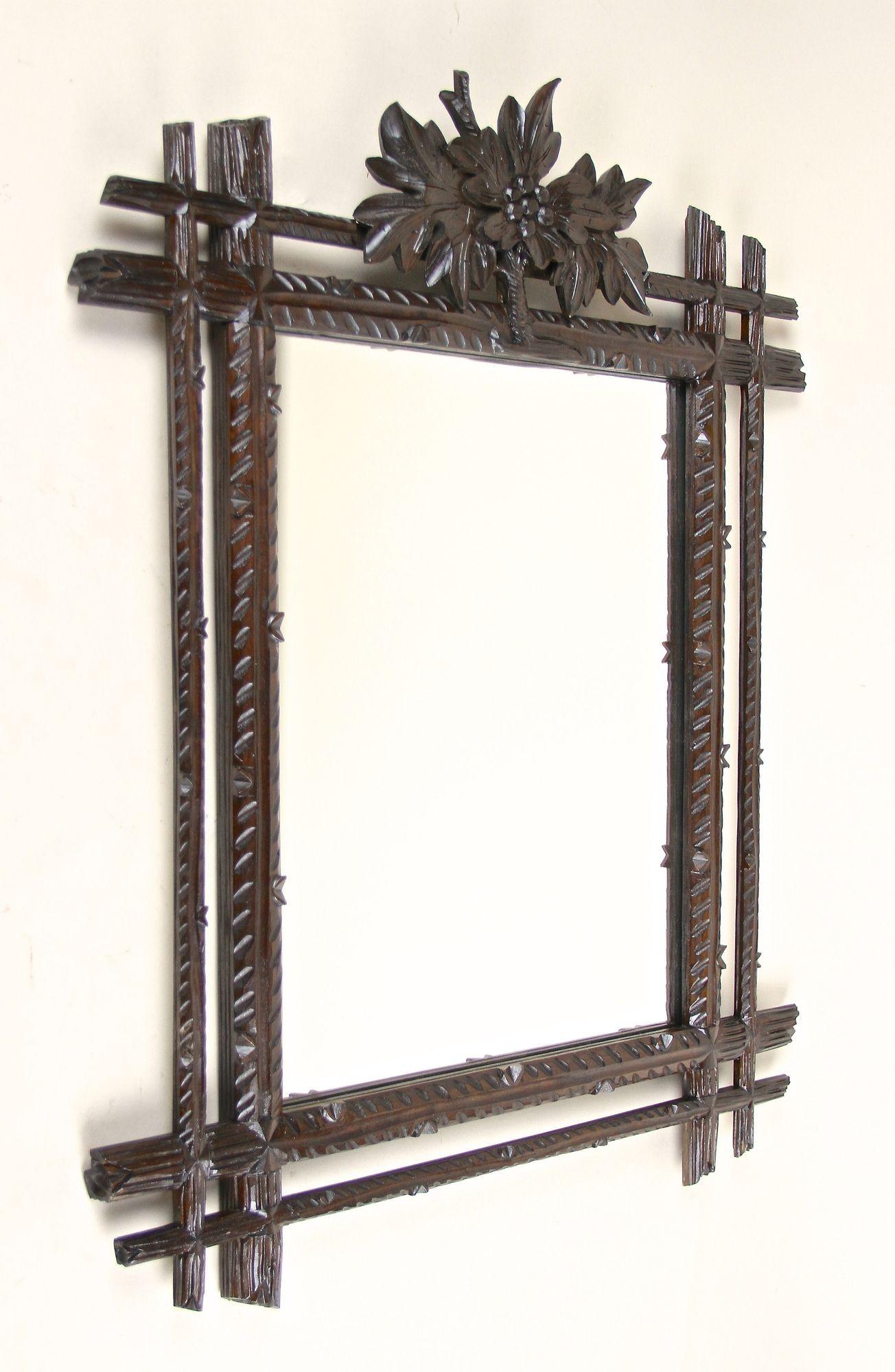 One of a kind rustic Black Forest wall mirror from the late 19th century in Austria. Elaborately handcarved out of fine basswood around 1890, this rural mirror shows an absolute mesmerizing design. The doubled frame with protruding corners impresses