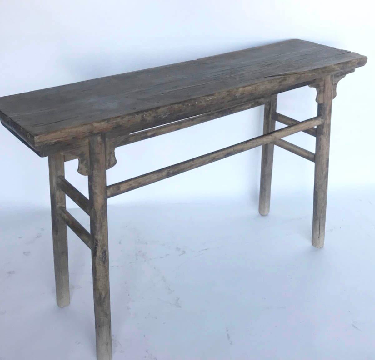 Antique Chinese Elm altar table with round legs and stretchers. Old butterfly joinery underneath top. Mortise and tenon construction. Corbel details. One wide board top. Age appropriate smooth, worn patina with traces of old finish. Overall original