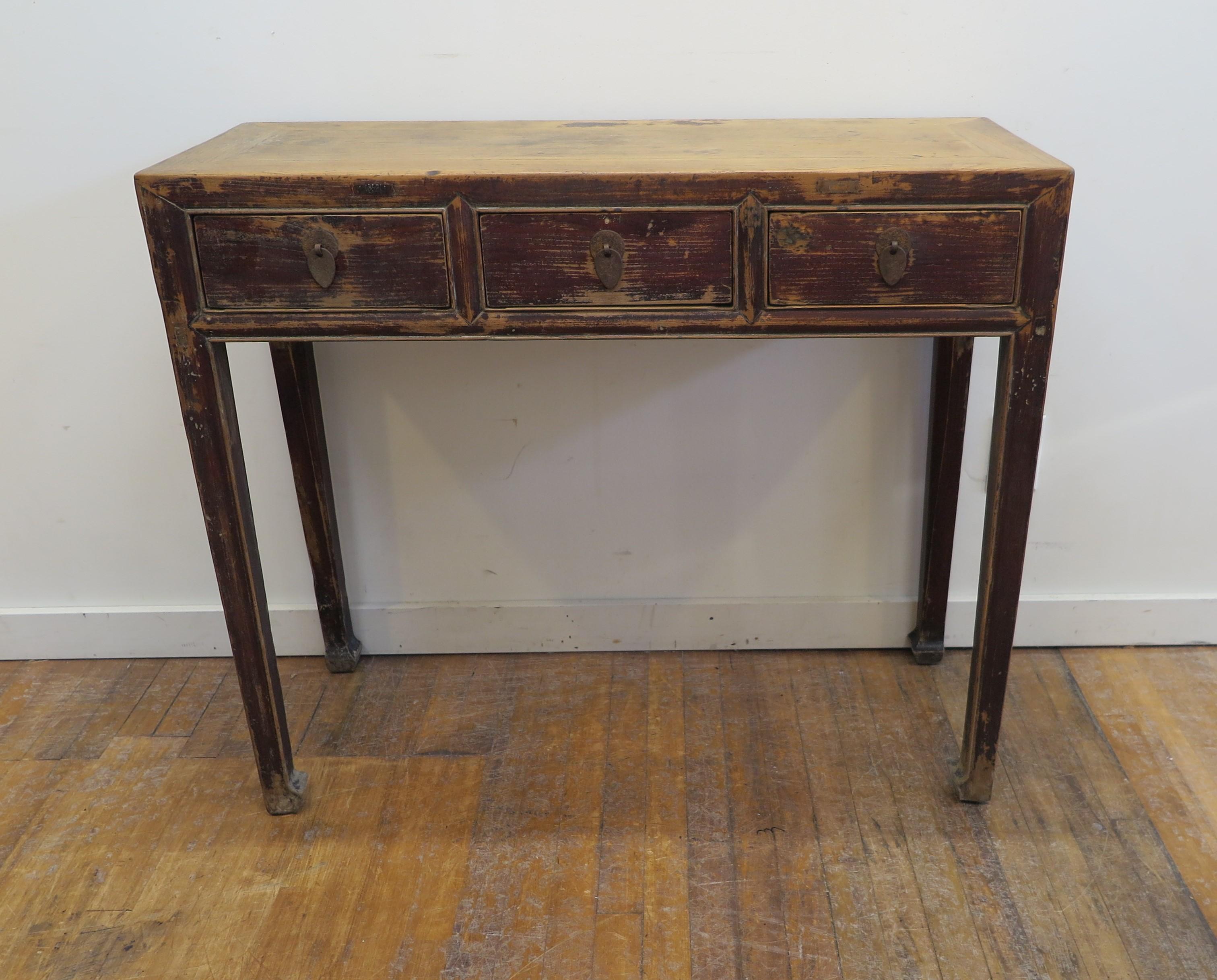 19th century rustic console table. Antique rustic three drawer console table. Chinese Elm wood with three drawers set on tapered legs terminating to hoofed feet. Wonderful time endured patina in very good condition. Strong and solid for everyday