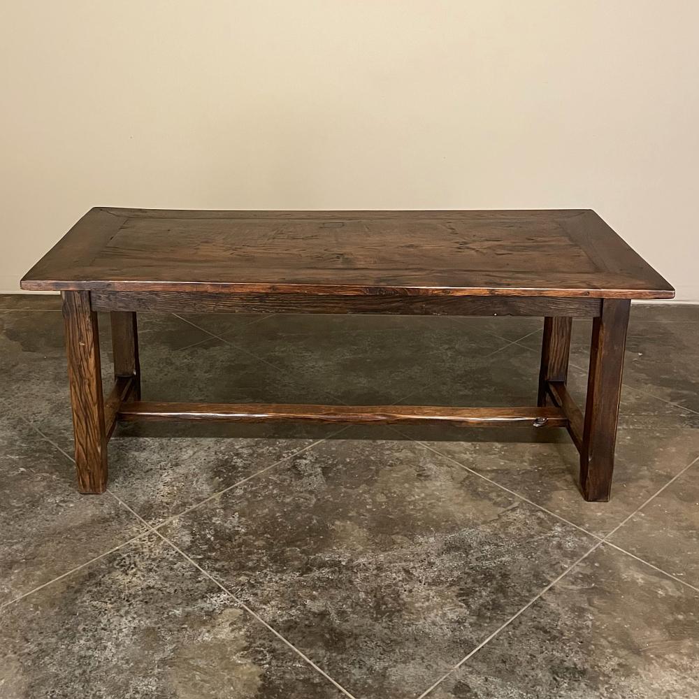 19th century rustic Country French farm table or dining table was completely hand-crafted from dense, old-growth indigenous oak to literally last for centuries! Solid plank top is supported by a wraparound recessed apron which in turn is attached to