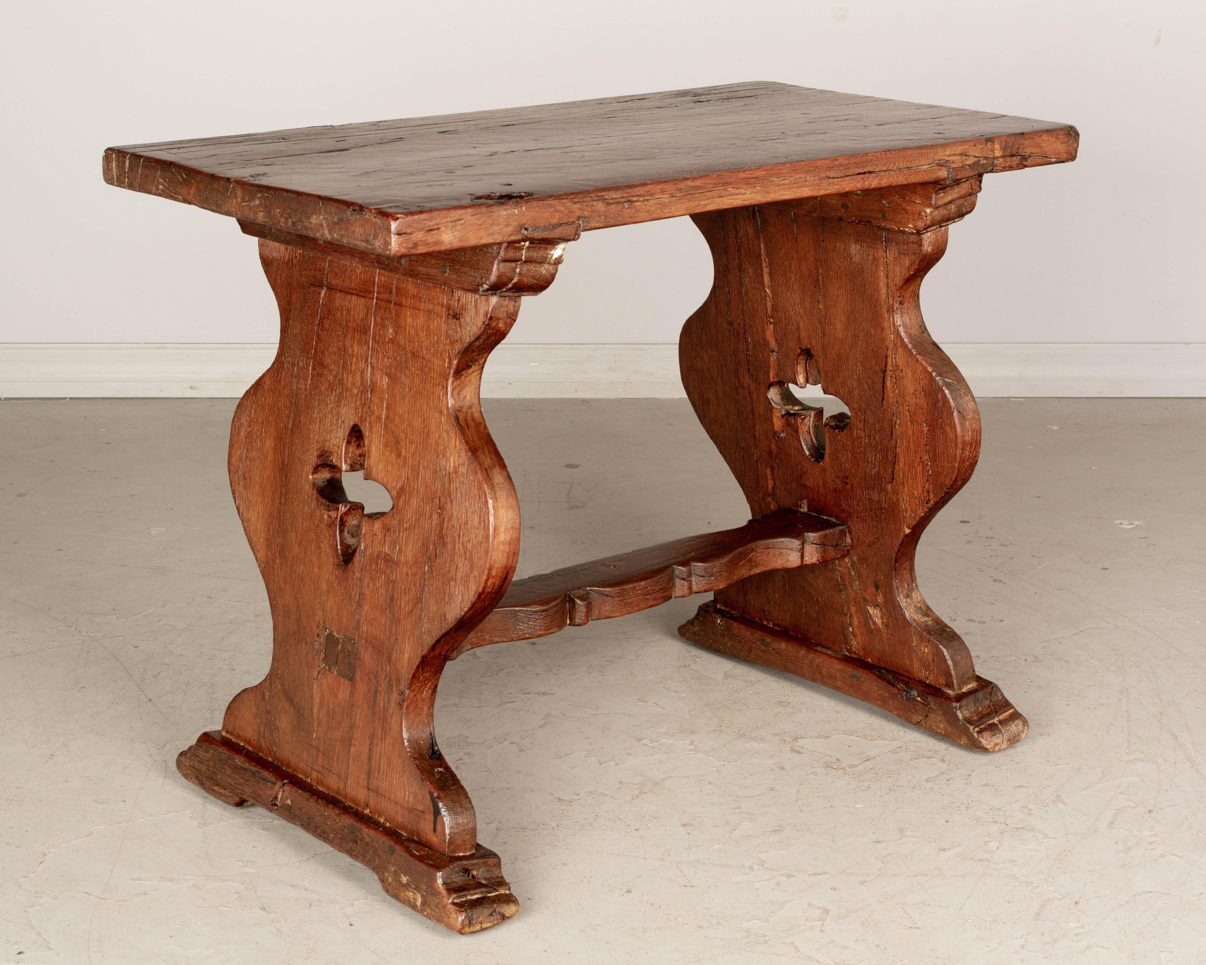 An early 19th century rustic oak side table from Central France. Hand-crafted with quatrefoil shaped cut-outs, thick plank top and shaped stretcher. A good sturdy versatile table. Waxed patina. Contact us for a competitive shipping quotation. Please