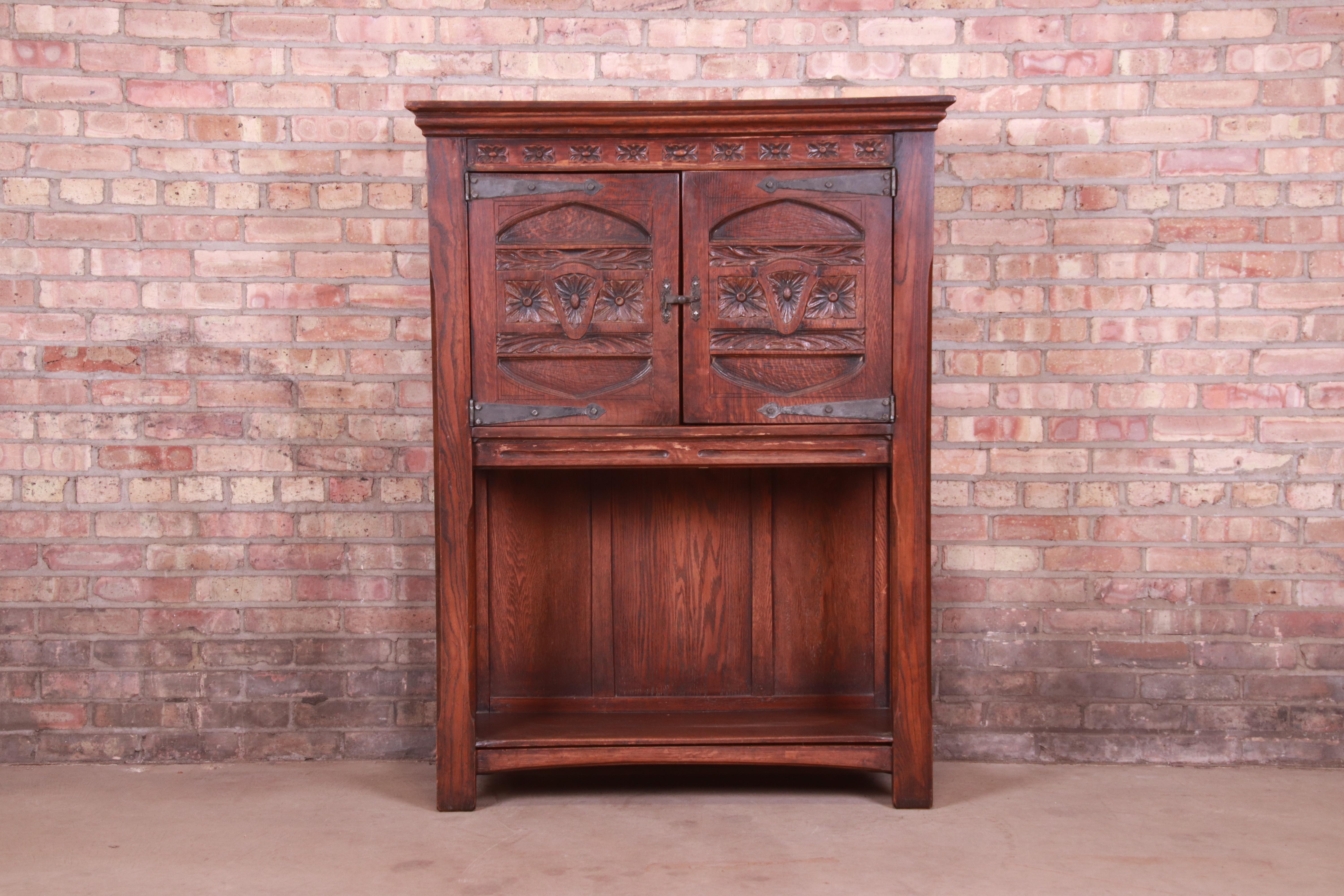 A gorgeous antique Rustic European or Gothic Revival bar cabinet

Likely Belgian; Late 19th Century

Carved solid oak, with original hammered iron hardware.

Measures: 40.63