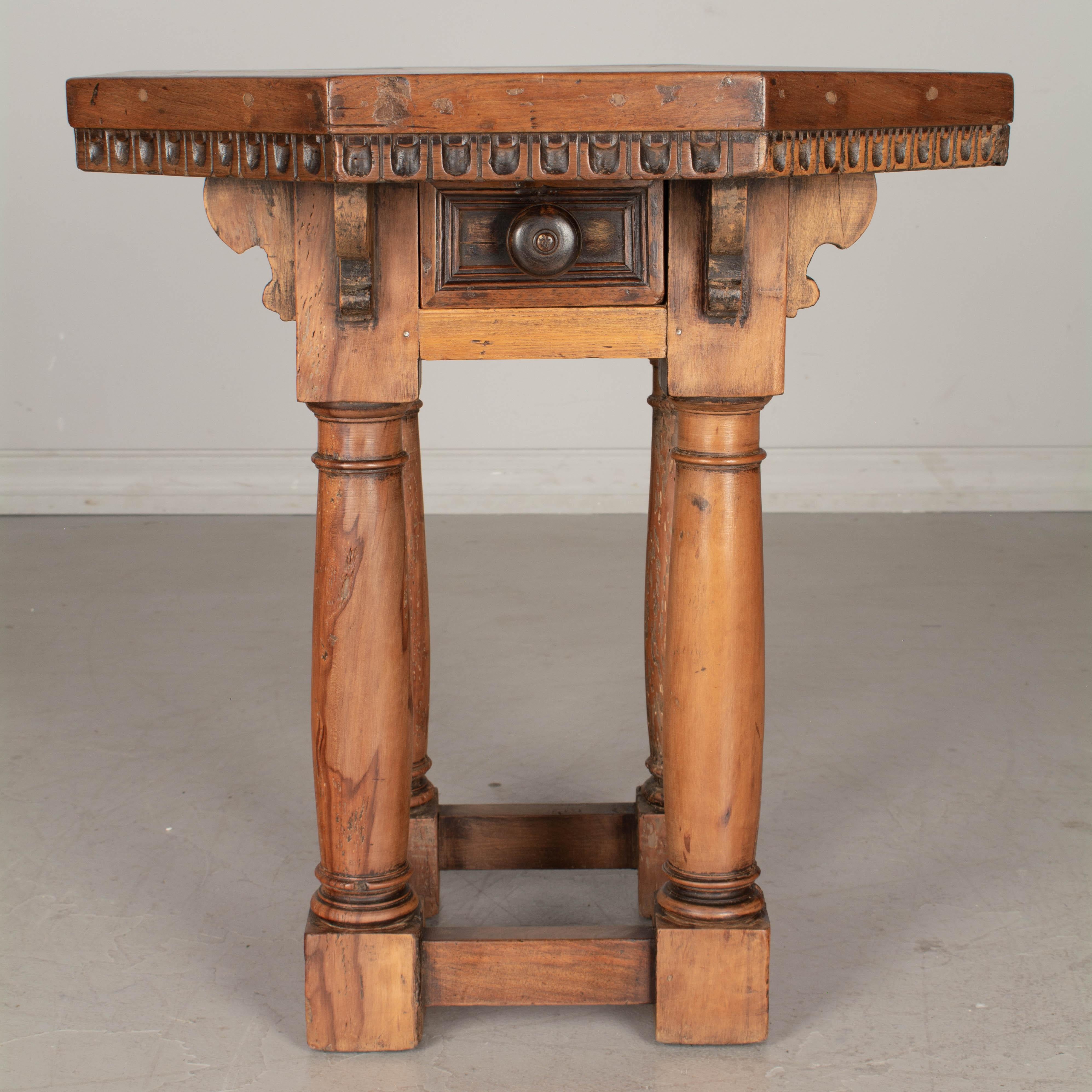A rustic 19th century French side table with hexagon shaped top. Made of walnut and cherry woods with turned legs joined by stretchers. Small dovetailed drawer with turned knob.