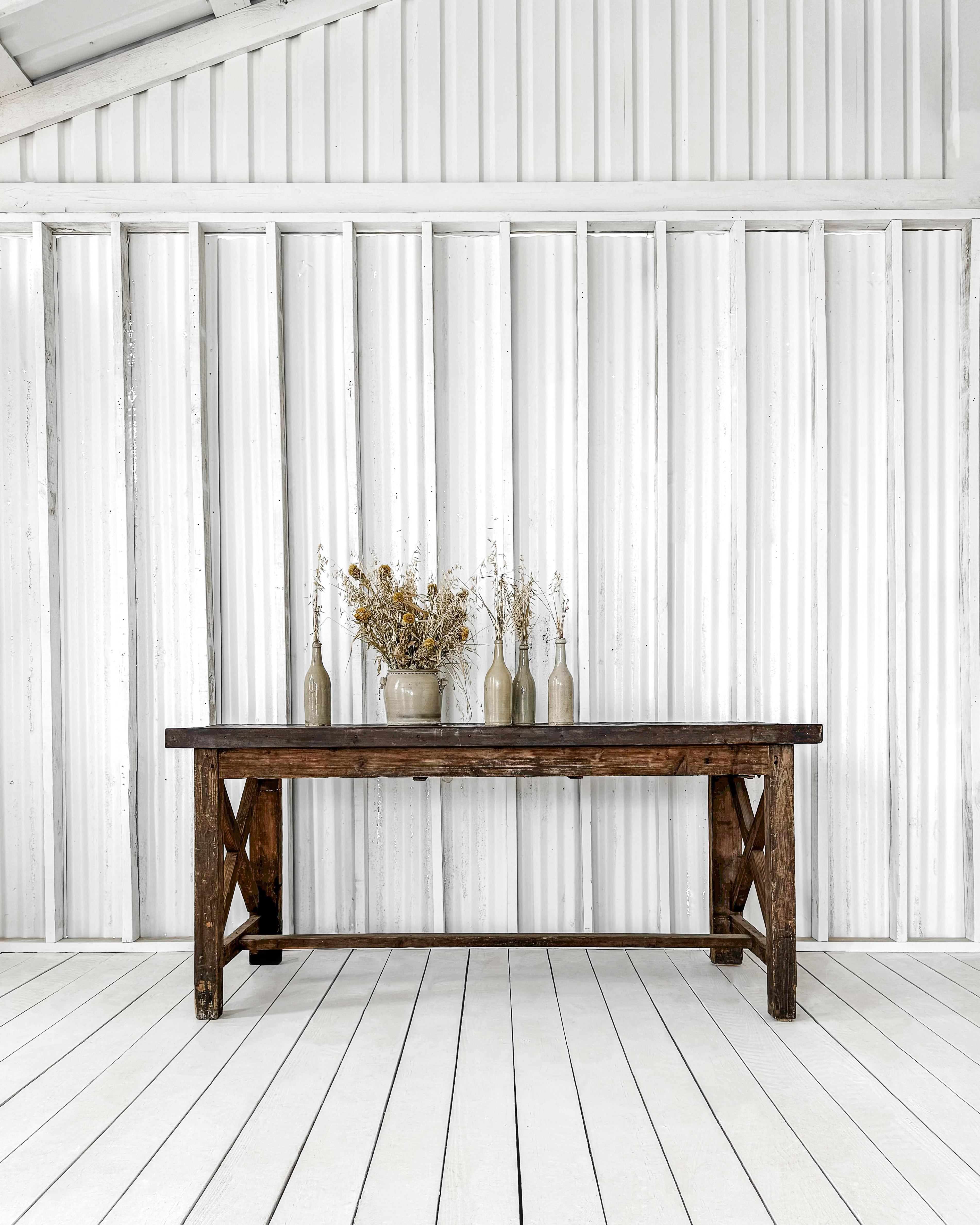 This rustic worktable with metal top is a handcrafted masterpiece featuring timeless craftsmanship. Crafted with meticulous attention to detail and pegged joinery by a skilled carpenter of the past, this remarkable worktable is the statement piece
