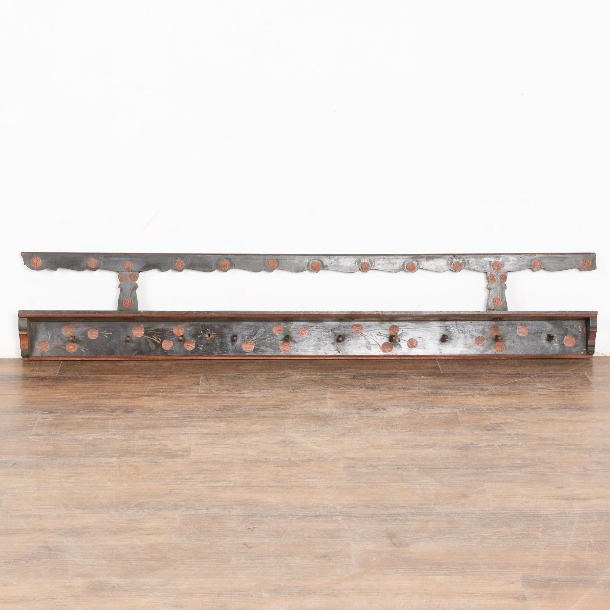 This delightful hanging rack is a wonderful example of the folk art found in Eastern Europe during the 1800's.
The dark brown background has hand painted accents including traditional red flowers and green leaves.
There are ten wood pegs for hanging