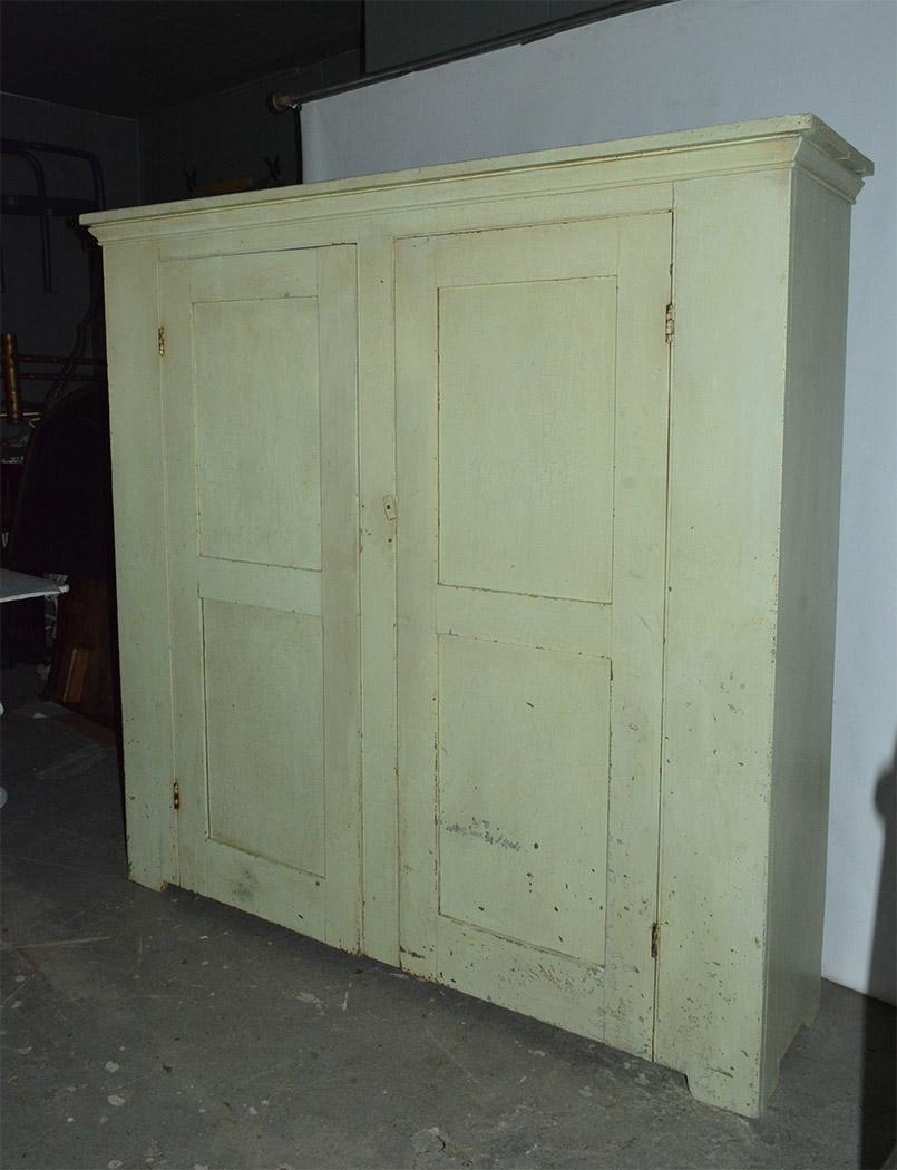 Large antique Hudson Valley farmhouse pantry storage cabinet. Two large doors with four interior shelves to provide much needed storage. With perfectly faded light green paint, mostly original with some refinished painted areas. The cupboard can