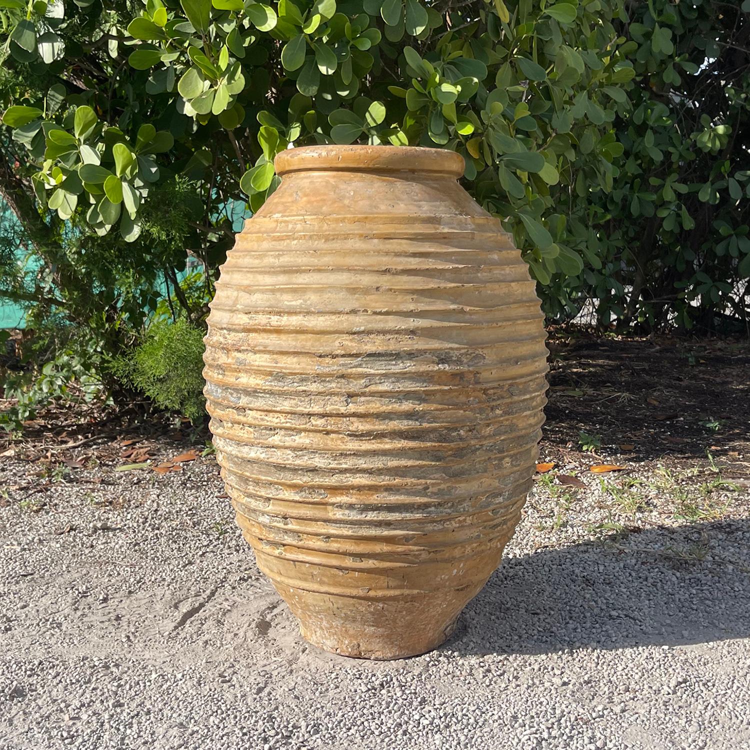 Antico vaso per olio d'oliva del Peloponneso mediterraneo con la tipica decorazione artigianale a coste Nekuma sul corpetto rotondo. Il bordo ha una glassa calda al miele. Questi antichi vasi da giardino venivano spesso utilizzati per la