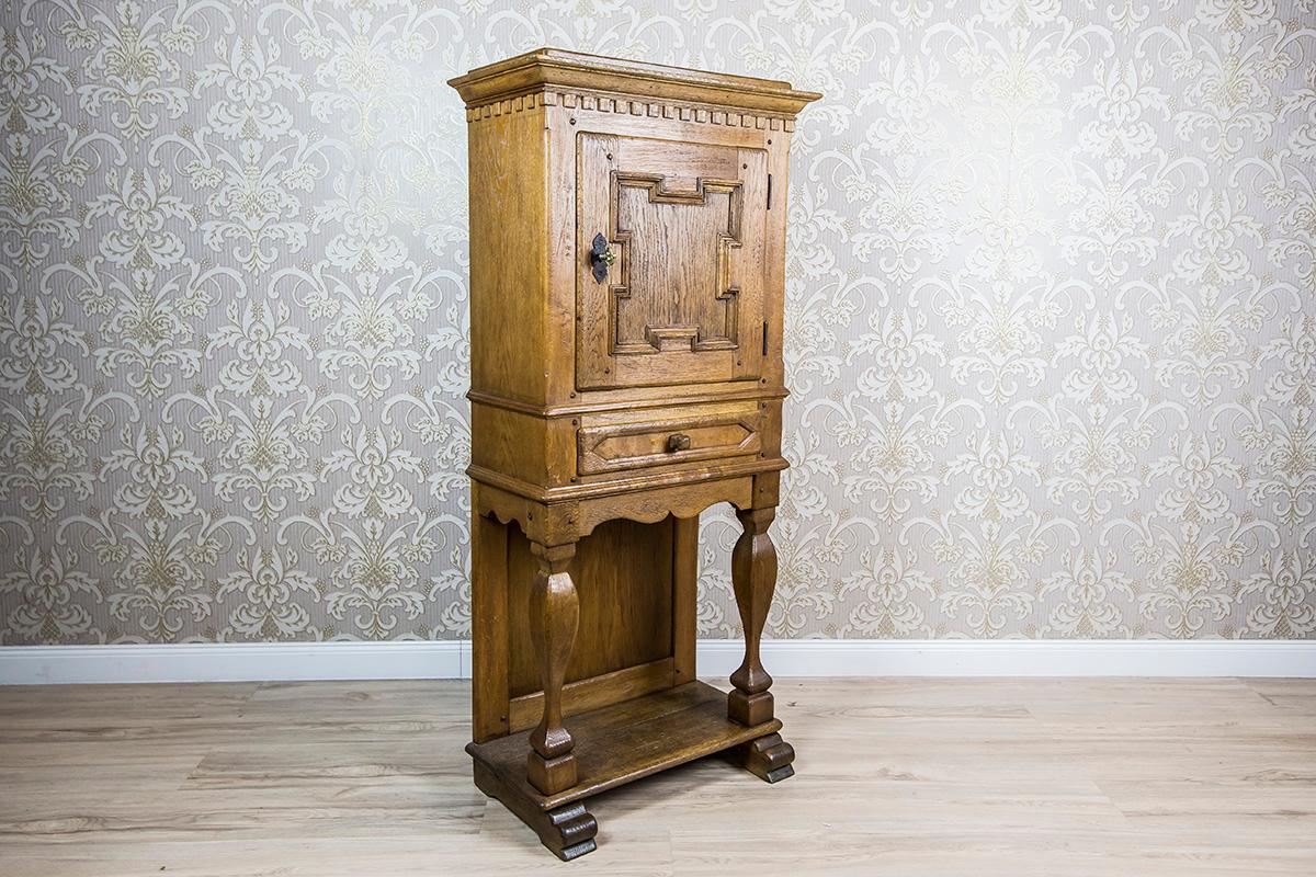 We present you a small cabinet manufactured in Germany.
This piece of furniture is of a rustic character, made entirely of oakwood.
It is dated Q4 of the 19th century.
The cabinet is composed of a single-leaf cabinet that is topped with a simple