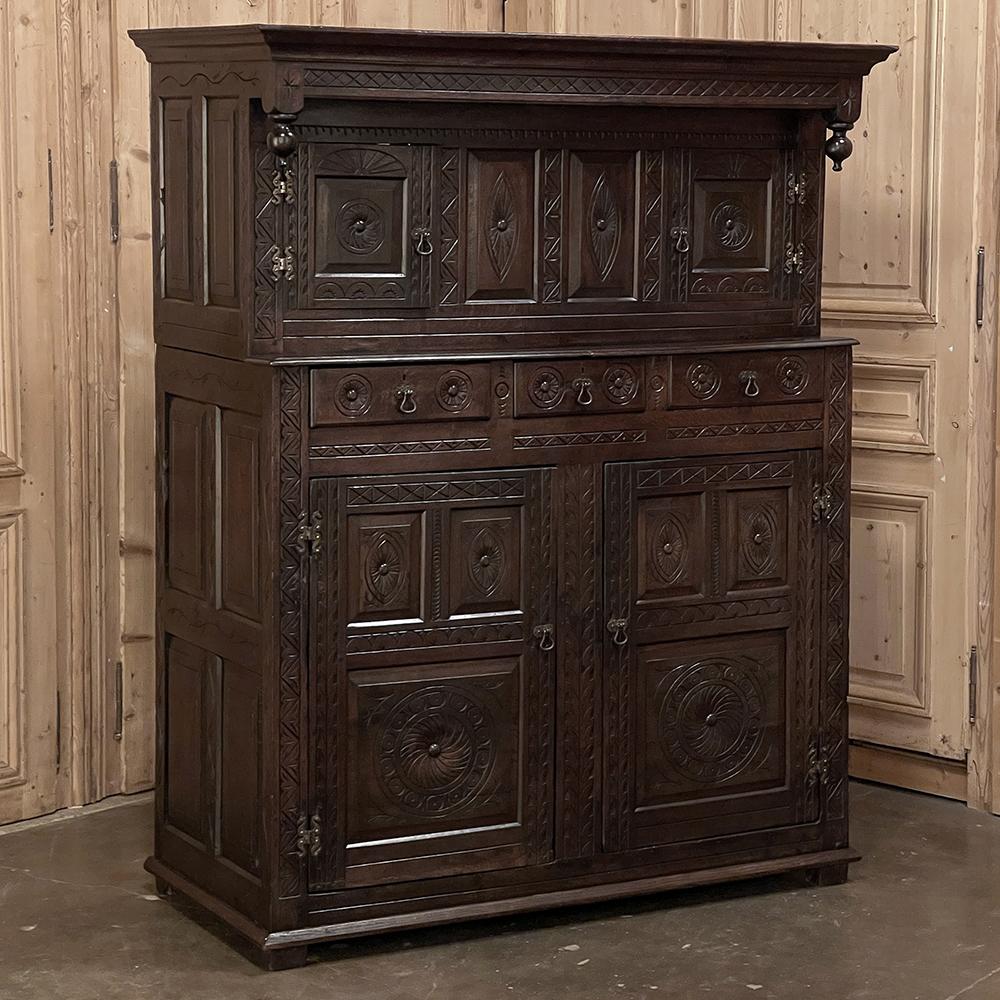 Der Rustic Renaissance Two-Tiered Cabinet aus dem 19. Jahrhundert ist die perfekte Lösung für mehr Stauraum mit Stil! Er ist aus massiver Eiche handgefertigt und verfügt über eine dezent vertiefte obere Etage, die von hängenden Finials flankiert