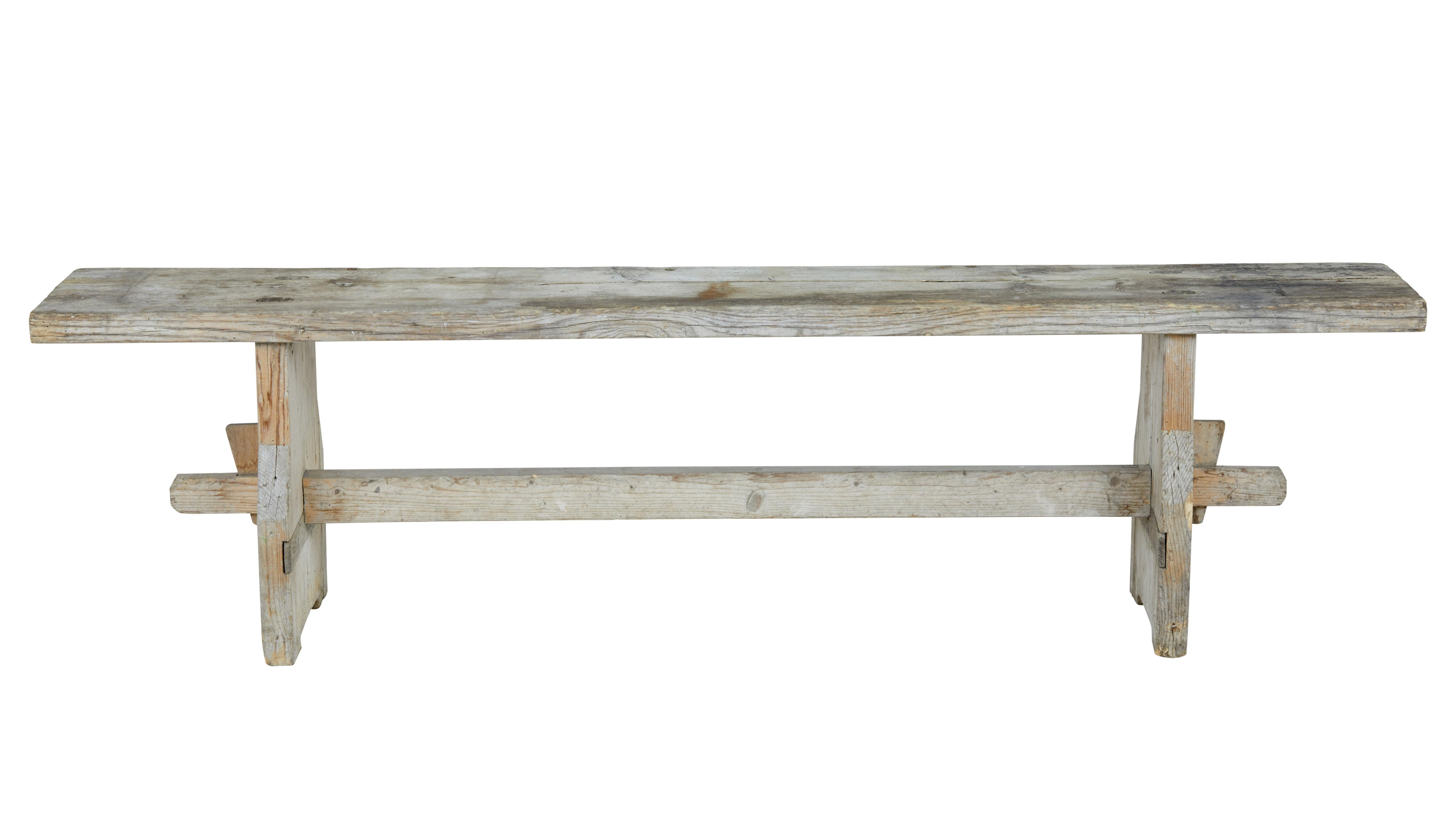 Rustic Swedish pine bench, circa 1880.

Made from heavy Siberian pine. Held in place by dowel and pegs, united by a central stretcher.

Age split to top with obvious signs of fading, evidence of dead treated worm, structurally sound.