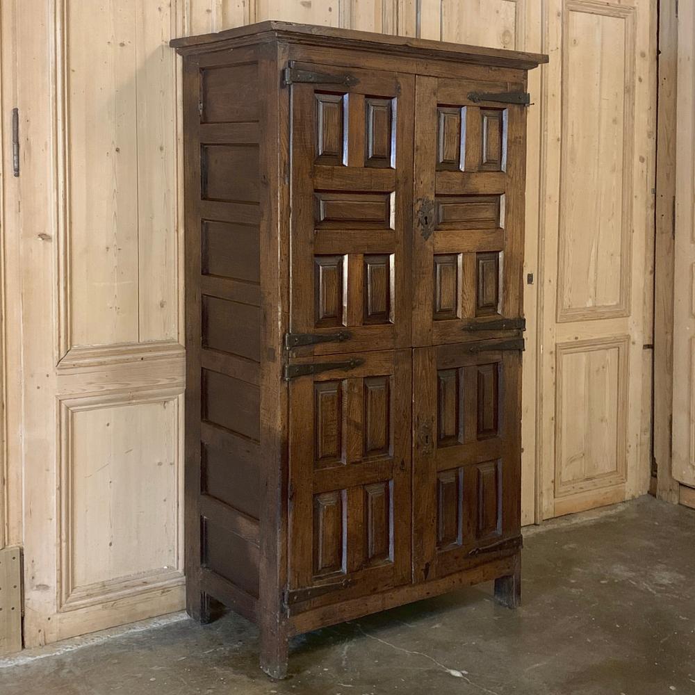 19th century rustic Spanish cabinet was built from local materials to last for generations, and features tailored raised panels and hand-forged iron hinges and hardware for a stunning casual effect. Heavy old-growth oak construction and