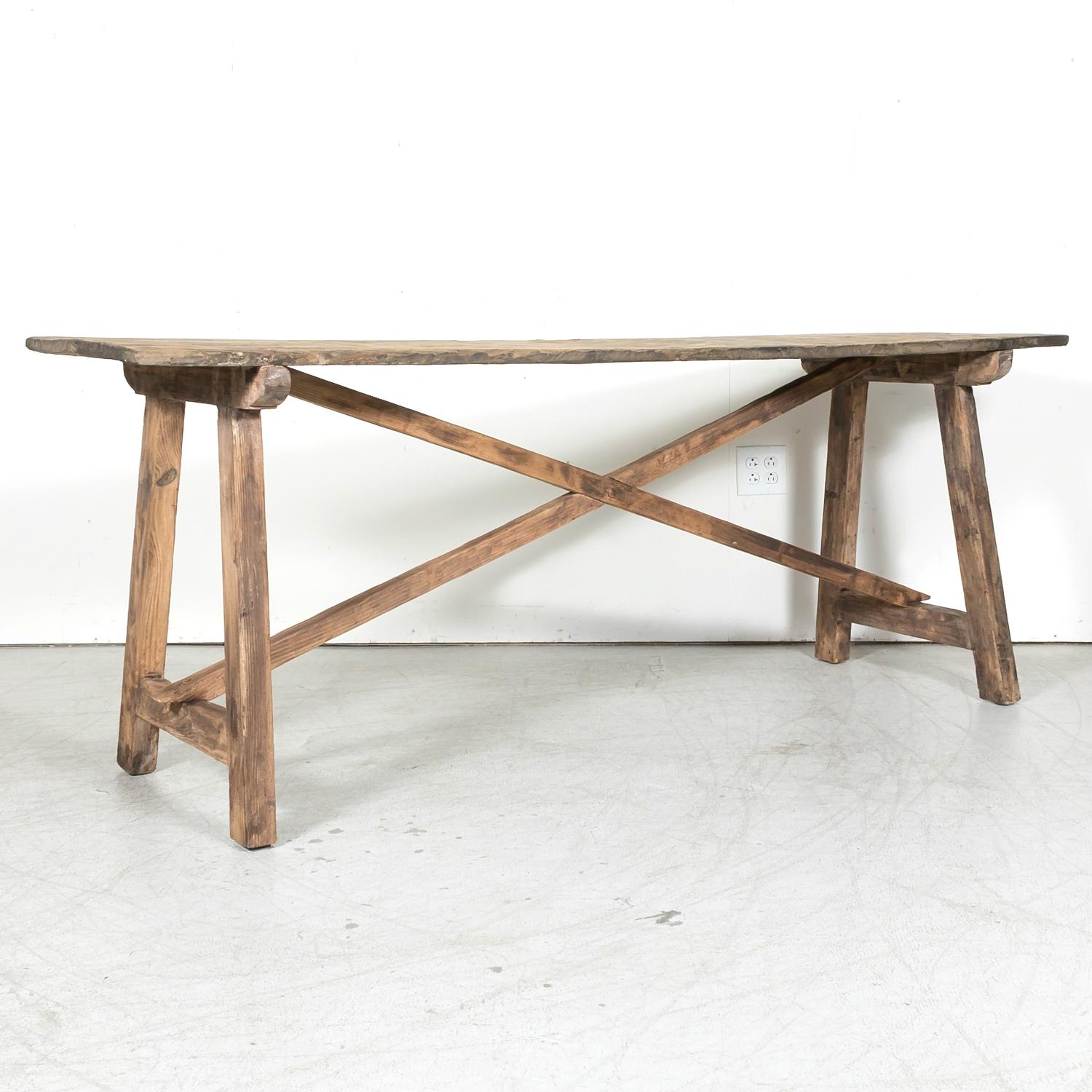A handsome 19th century rustic Spanish console or side trestle table handcrafted of solid oak and pine in the Catalan region, circa 1890s. Having a solid oak top resting on a pine trestle base joined by an 