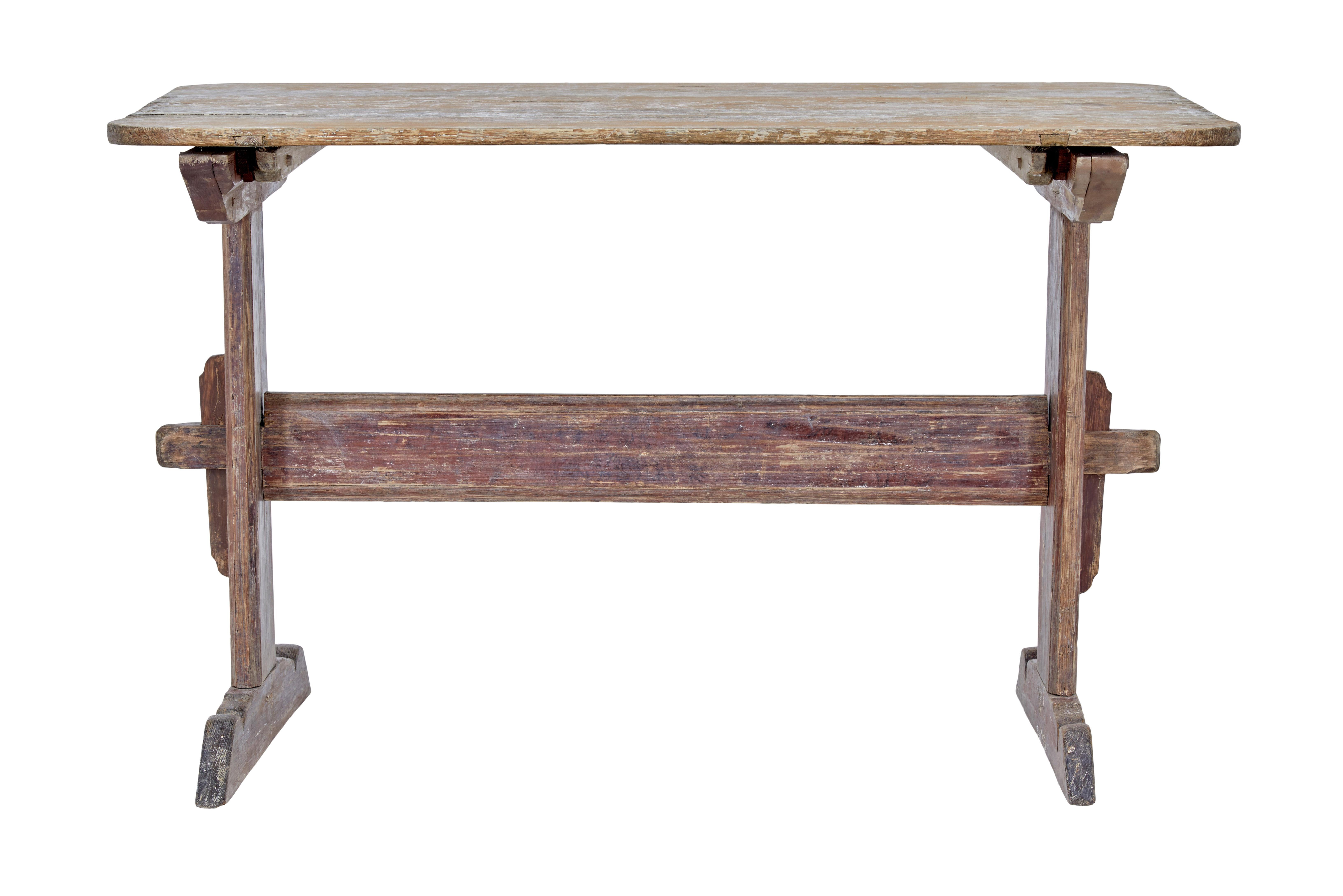 19th century rustic Swedish painted trestle table circa 1840.

Here we have a traditional Swedish table with traces of the original paint.

Light orange painted top with evidence that it may have been used for baking, supported red painted