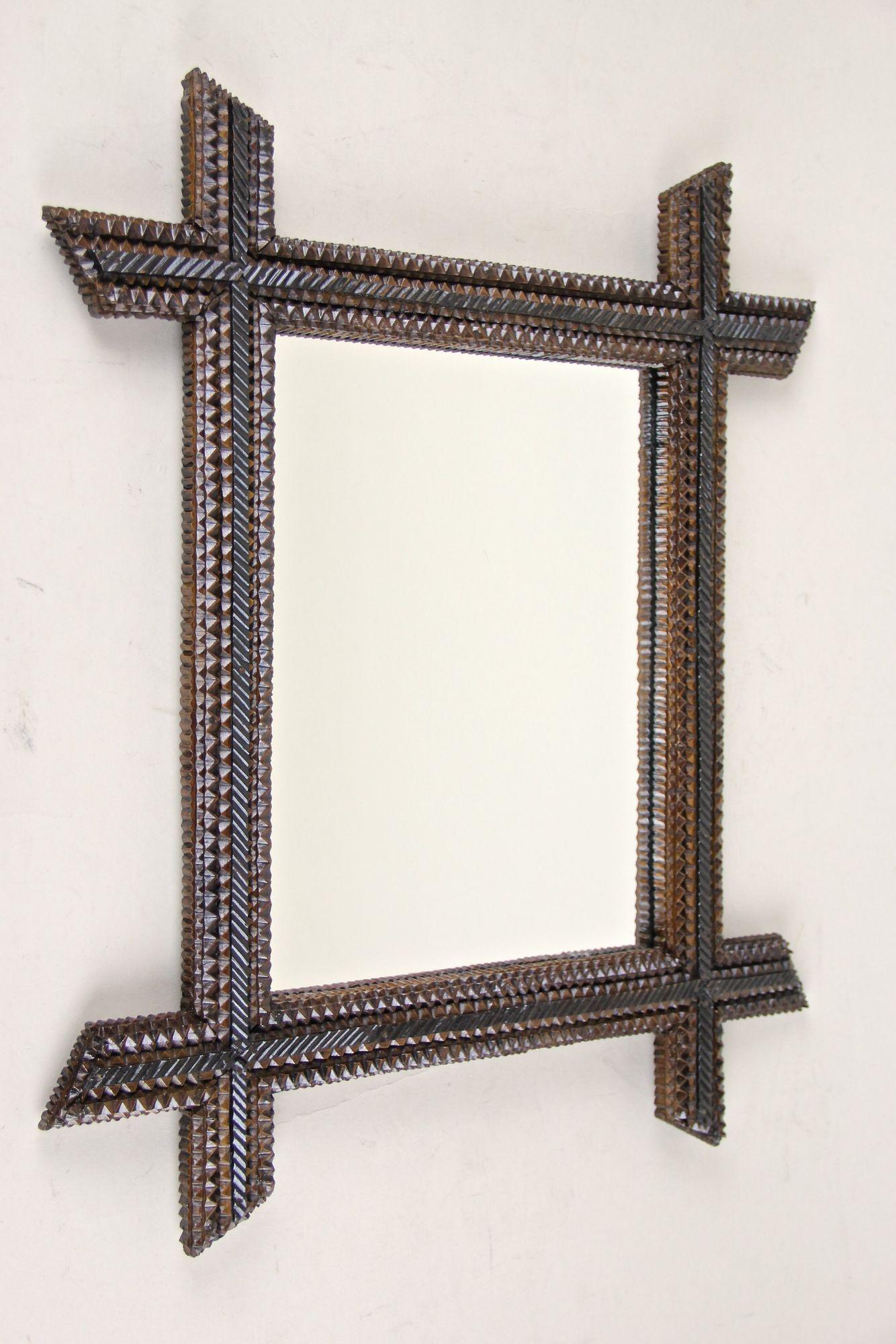 Fantastic looking, rustic 19th century Tramp Art wall mirror from the period around 1880. This charming mid-sized rustic mirror comes out of Austria and convinces by its great variety of different notch cut carvings. Protruding, beveled corners and