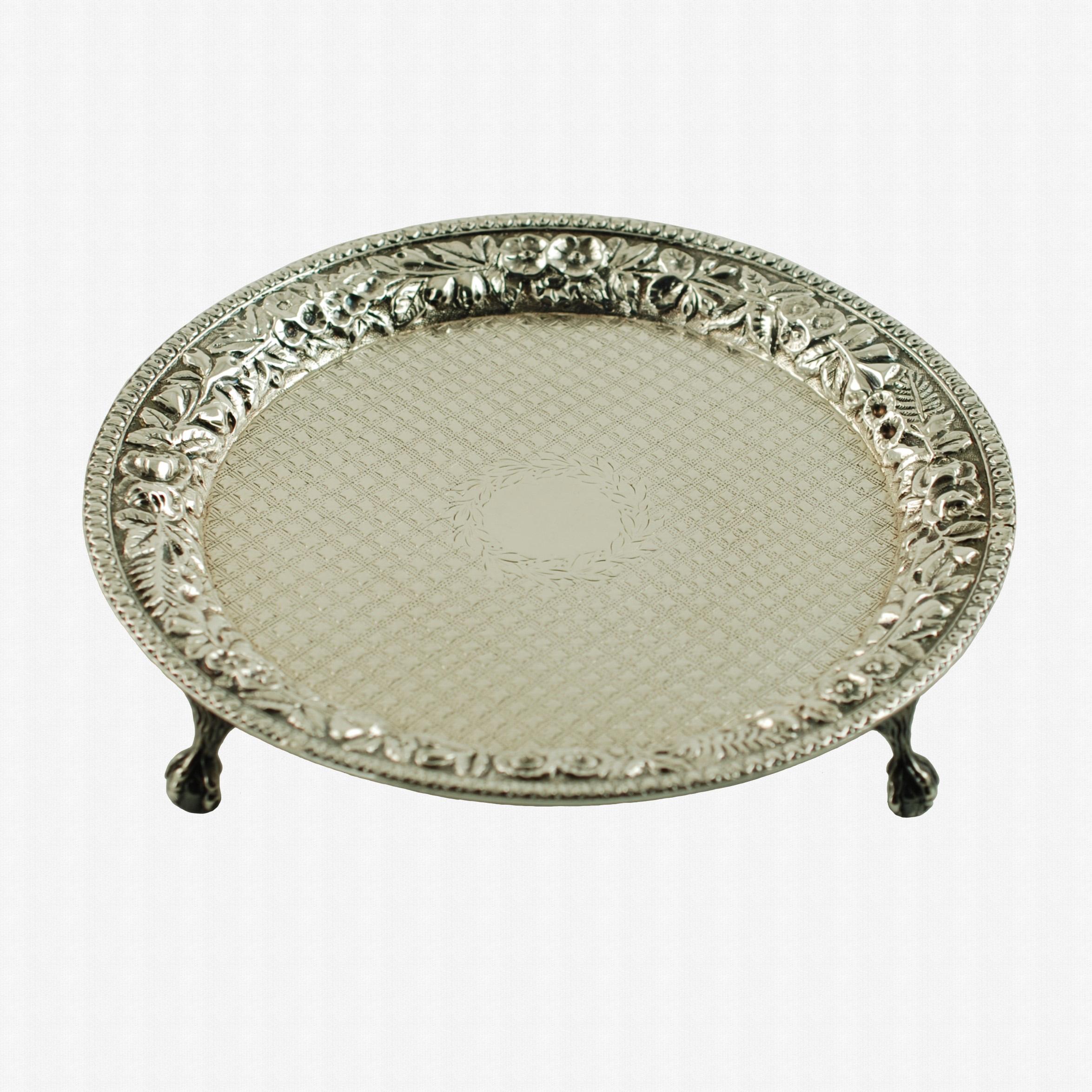 This elegant late 19th century silver salver was made by Baltimore, Maryland based silver manufacturer, S. Kirk & Son. The piece features an ornate chased floral shoulder finished with a banded rim. The face of the tray is decorated with an