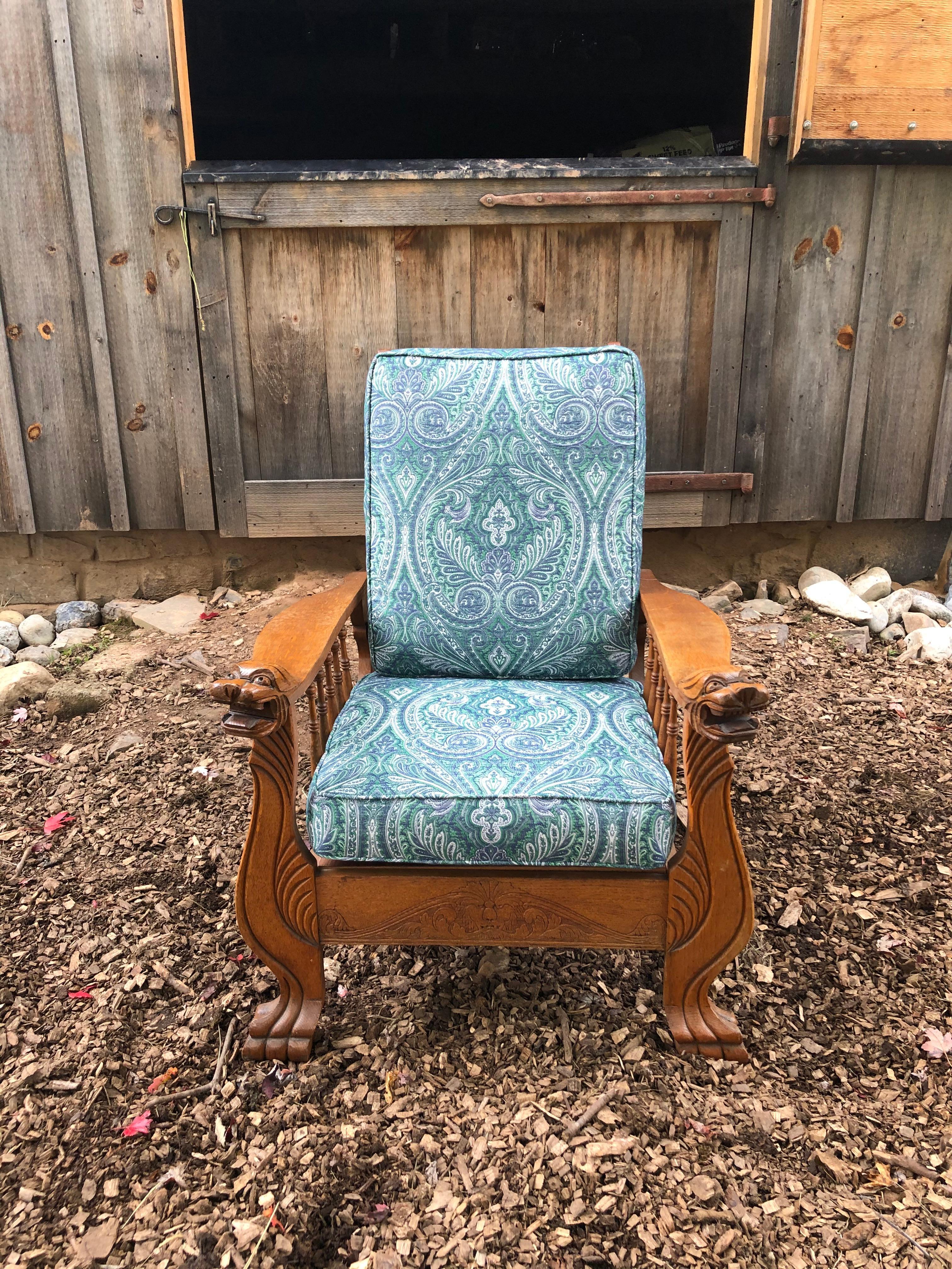An authentic S.A.Cook carved oak reclining Morris chair having fantastic growling carved griffin hand rests. Custom cushions are covered in a blue and white paisley.
Measures: Arm height 26.5
Seat depth 20
Arm to arm 29.5 W
Leg to leg 30.5 W.