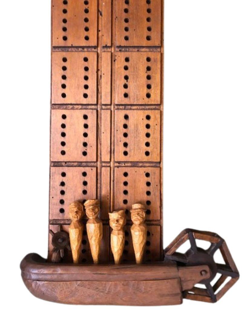 Tavola da cribbage intagliata da marinaio del XIX secolo con barca a pale e pioli figurati, firmata 