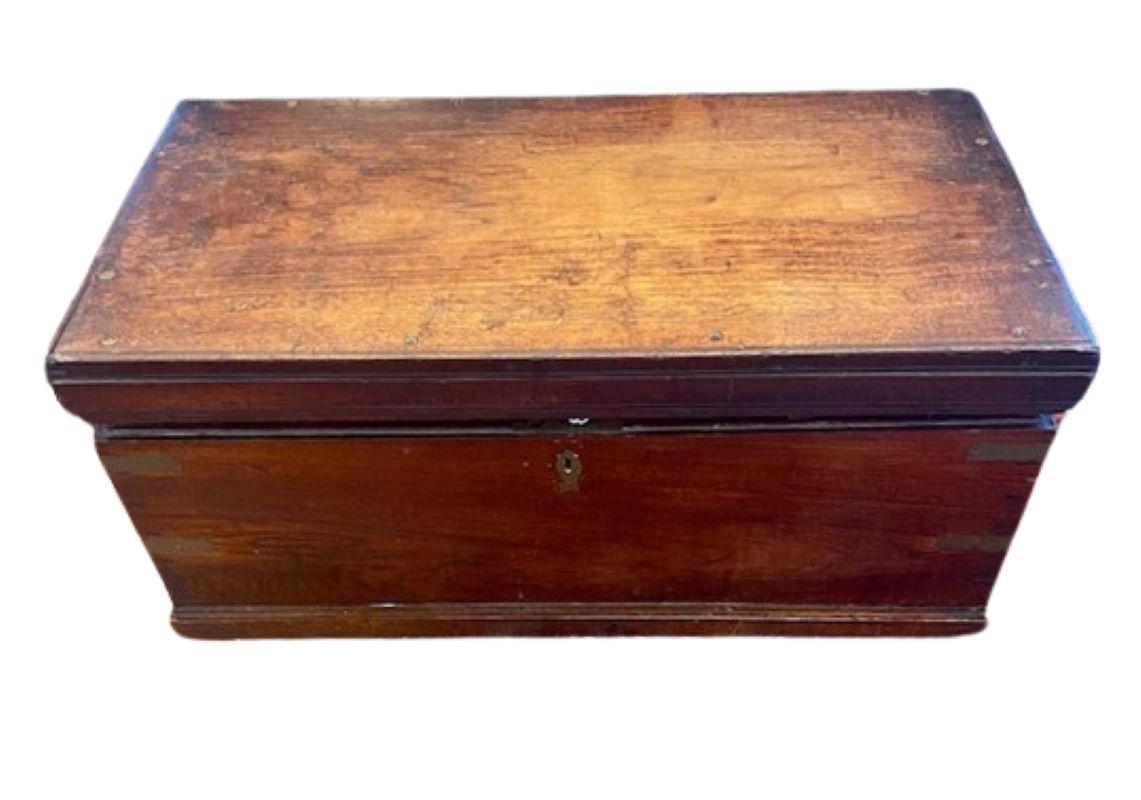 Antique Sailor's Sea Chest, Late 19th Century, a British sailor's sea chest made from tropic hardwood, possibly teak, of heavy, solid brass-bound construction with dove-tailed joints, reinforced molding around top and base, and a unique fish-shaped