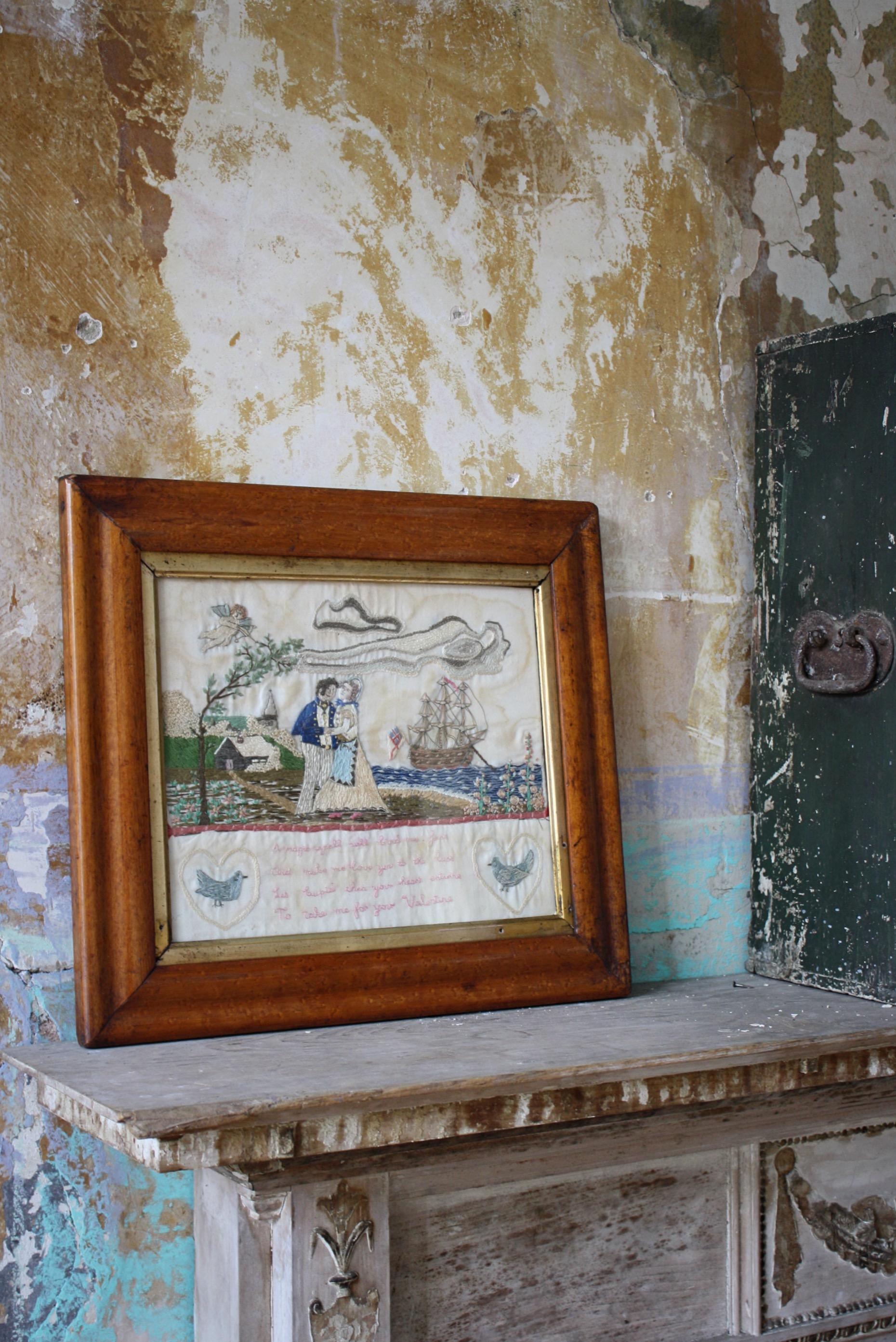 A particularly well executed needlework of a sailor and his sweetheart in a landscape, with his returning vessel in the background, cupid in the corner readying his bow and doves either side of the verse

'A magic spell will bind me fast 
And
