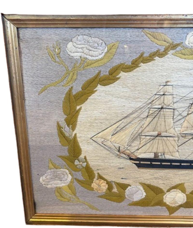 19th Century Sailor's Woolie of a British Frigate Within Floral Reserve, circa 1840, a British Sailor's hand-crafted woolwork picture with a larboard side view of a ship-rigged frigate under sail with main course furled, flying the white ensign off