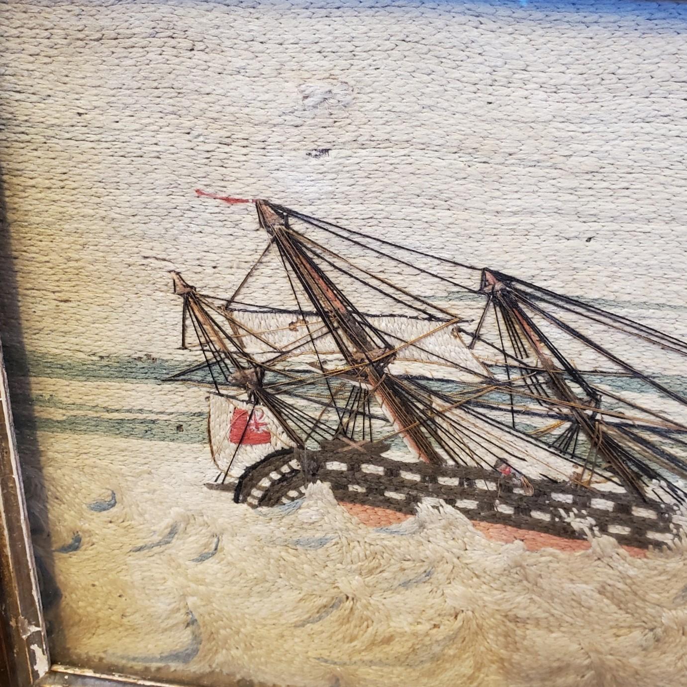 19th Century Sailor's Woolie of a Shipwreck, circa 1840, a woolwork depicting a British double decker warship battling heavy seas, having struck a sandbar and laid on beam ends with the pinkish-red copper clad bottom exposed and the bowsprit broken