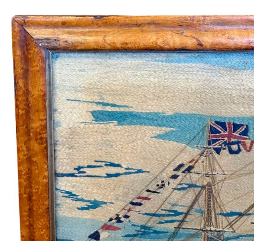 19th Century Sailor's Woolie of Flag-Bedecked Triple Decker Ship of the Line, circa 1850, a British sailor's hand-crafted woolwork picture with a larboard side view of a triple decked ship-of-the-Line under furled sails, fully dressed with Blue