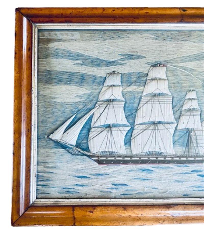 19th Century Sailor's Woolie, circa 1860, a sailor's folk art woolwork picture of a British frigate with white trapunto sails, the ensign of the White Fleet at the stern, and the fleet admiral's long white pennant flying from the main mast peak, set