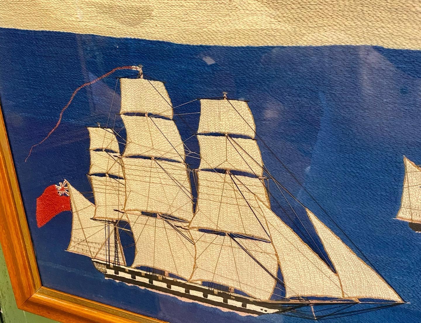Antique British Sailor's Woolie, circa 1890, a large hand crafted folk art woolwork featuring a large British Frigate under full sail with over-sized British ensign flying on the spanker gaff and ship's flag at the Main peak; two Austrian Topsail