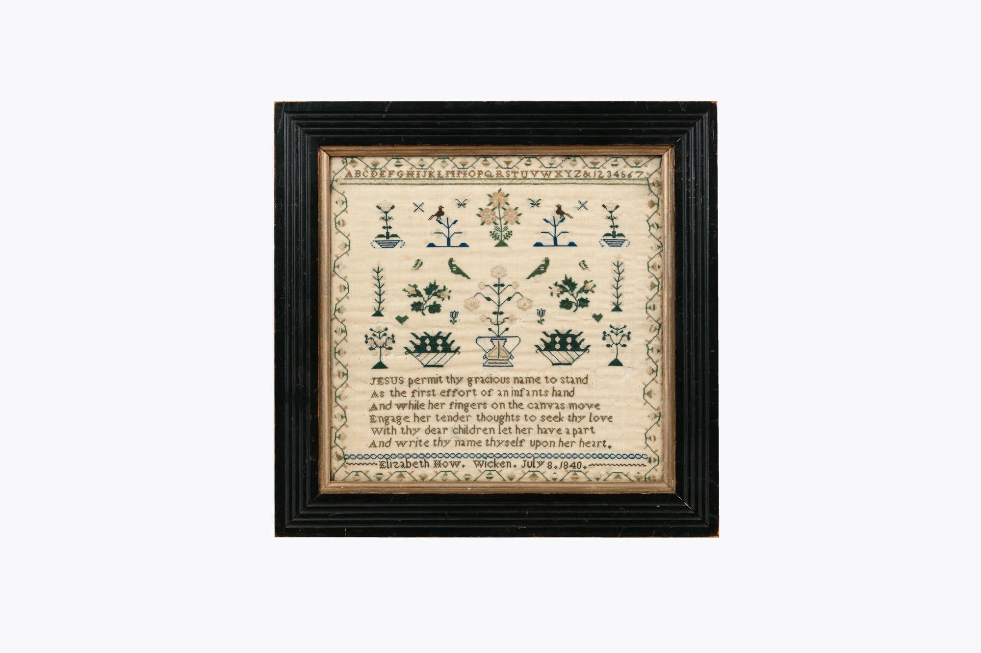 Mustertuch aus dem 19. Jahrhundert mit gestickter religiöser Inschrift und floraler Dekoration. Datiert auf 1840.