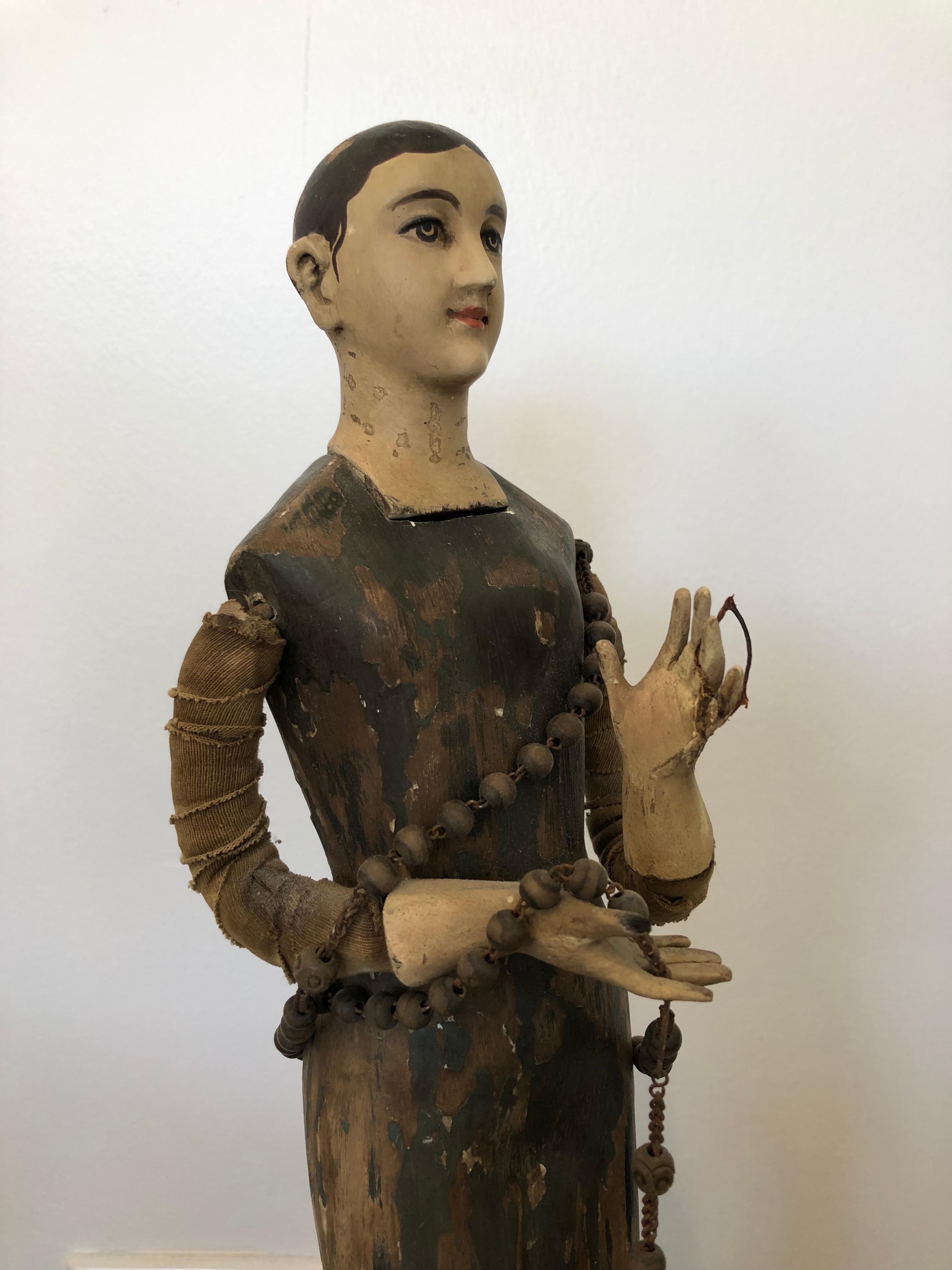 19th century Santos Doll Figure. She is holding a rosary and all fingers are in tact and arms and hands articulated. Gorgeous patina.