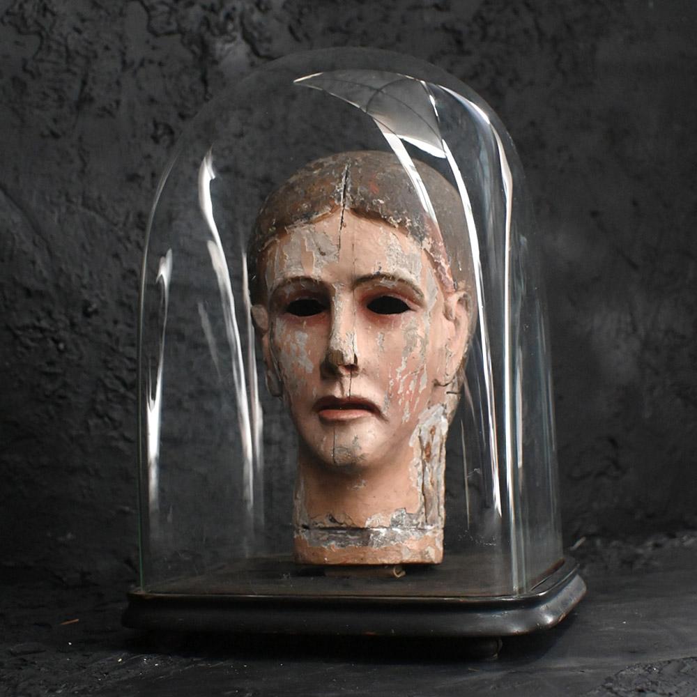 19th Century Santos Head

An early 19th Century hand carved Italian Santos Head. Formed from hand carved sections of pine wood, some paint still present leaving a macabre and spooky look due to the hollow eyes. Housed in a 19th Century ebonised pine
