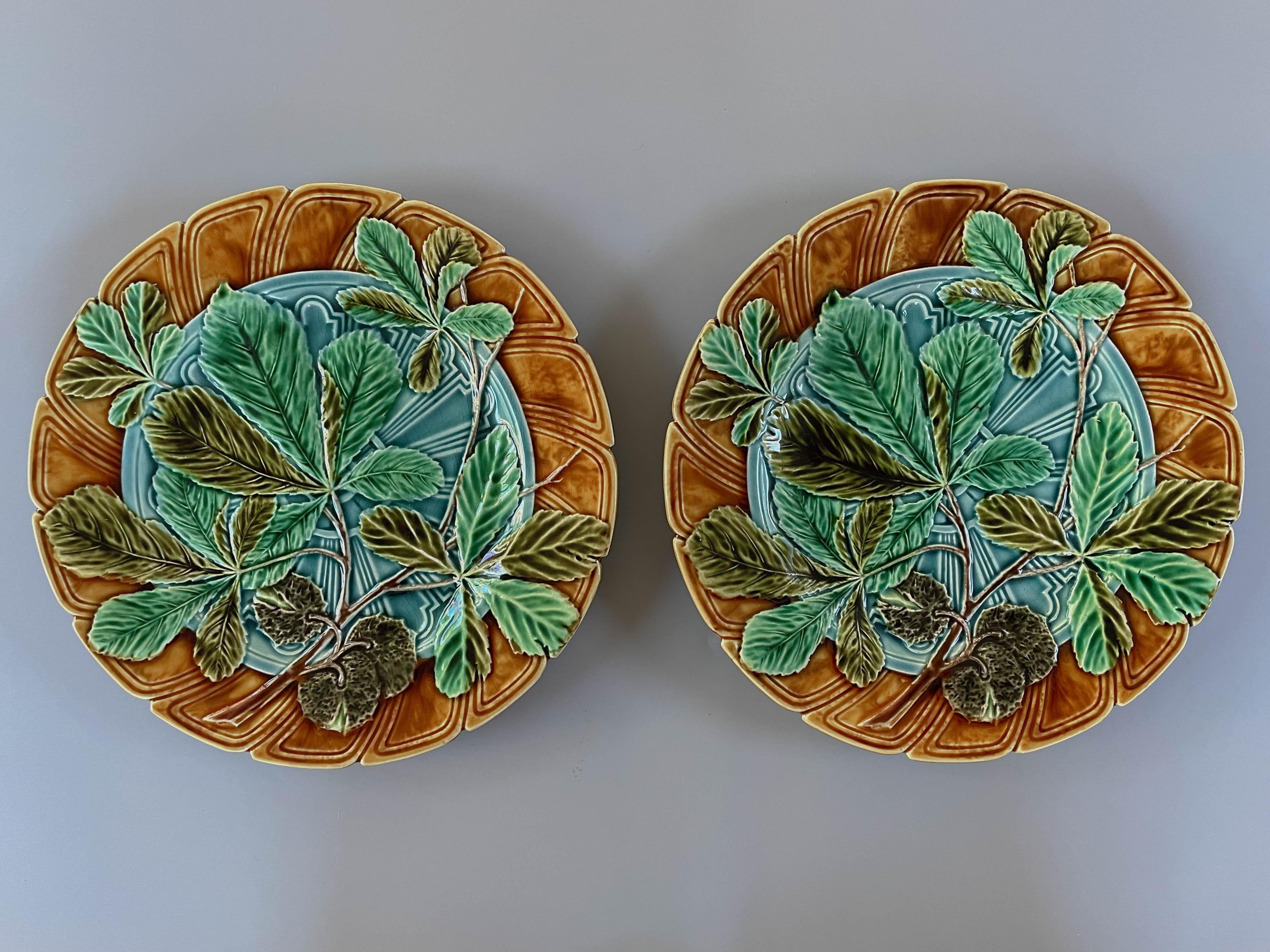 Ein Paar französischer Sarreguemines Majolika-Teller aus dem 19. Jahrhundert, glasiert, mit Kastanienblattmuster in Grüntönen, auf türkisblauem Grund und ockerfarbenem Rand. Blaue Glasur auf der Rückseite. Verso bezeichnet: Majolika Sarreguemines.