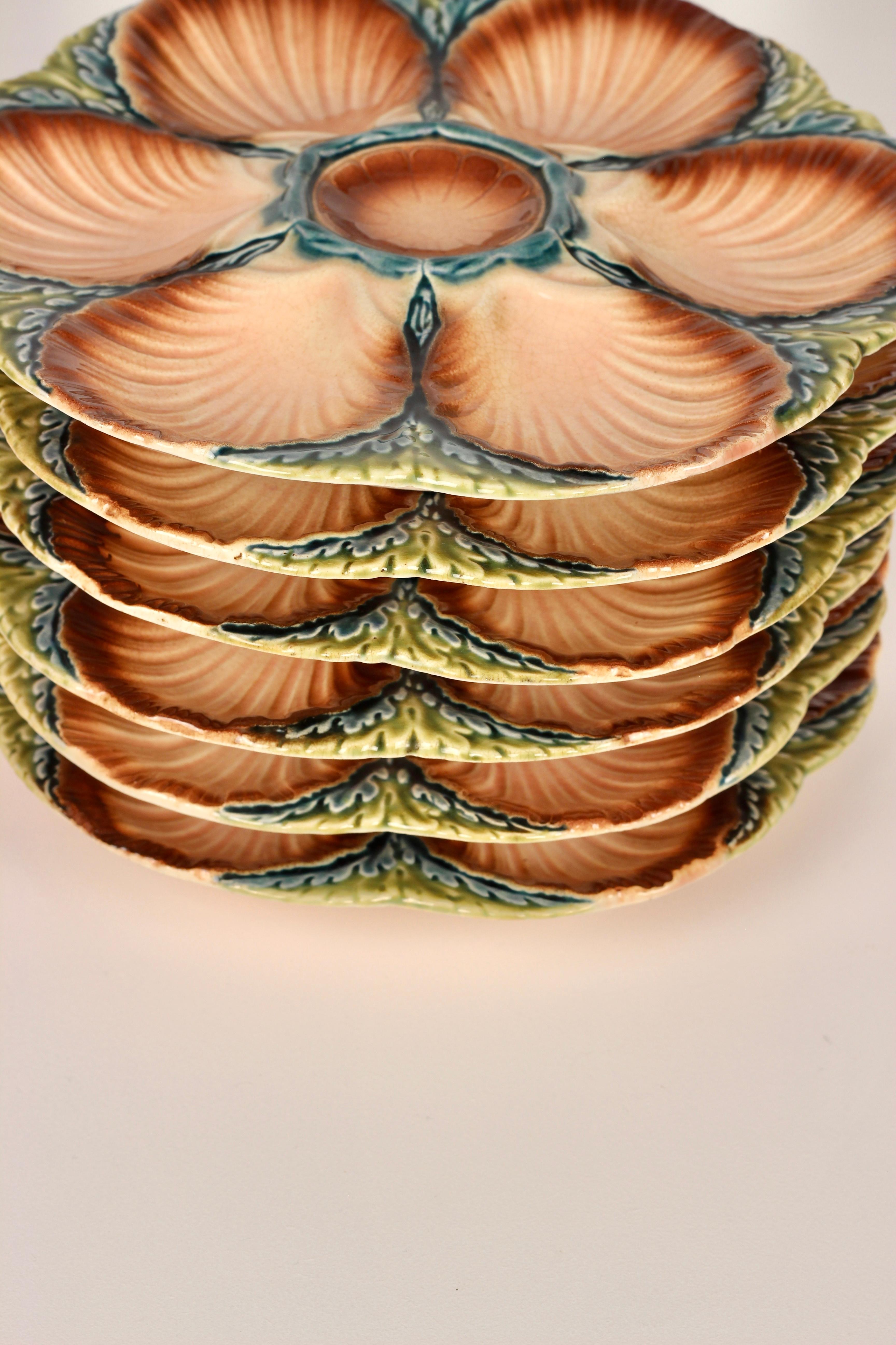Creating a wonderful display for Oysters or sea food this French Majolica oyster plate in lustrous deep colouring, but the well thought of maker Sarreguemines, circa 1890. Six scallop shell shaped wells surround a raised centre condiment well for