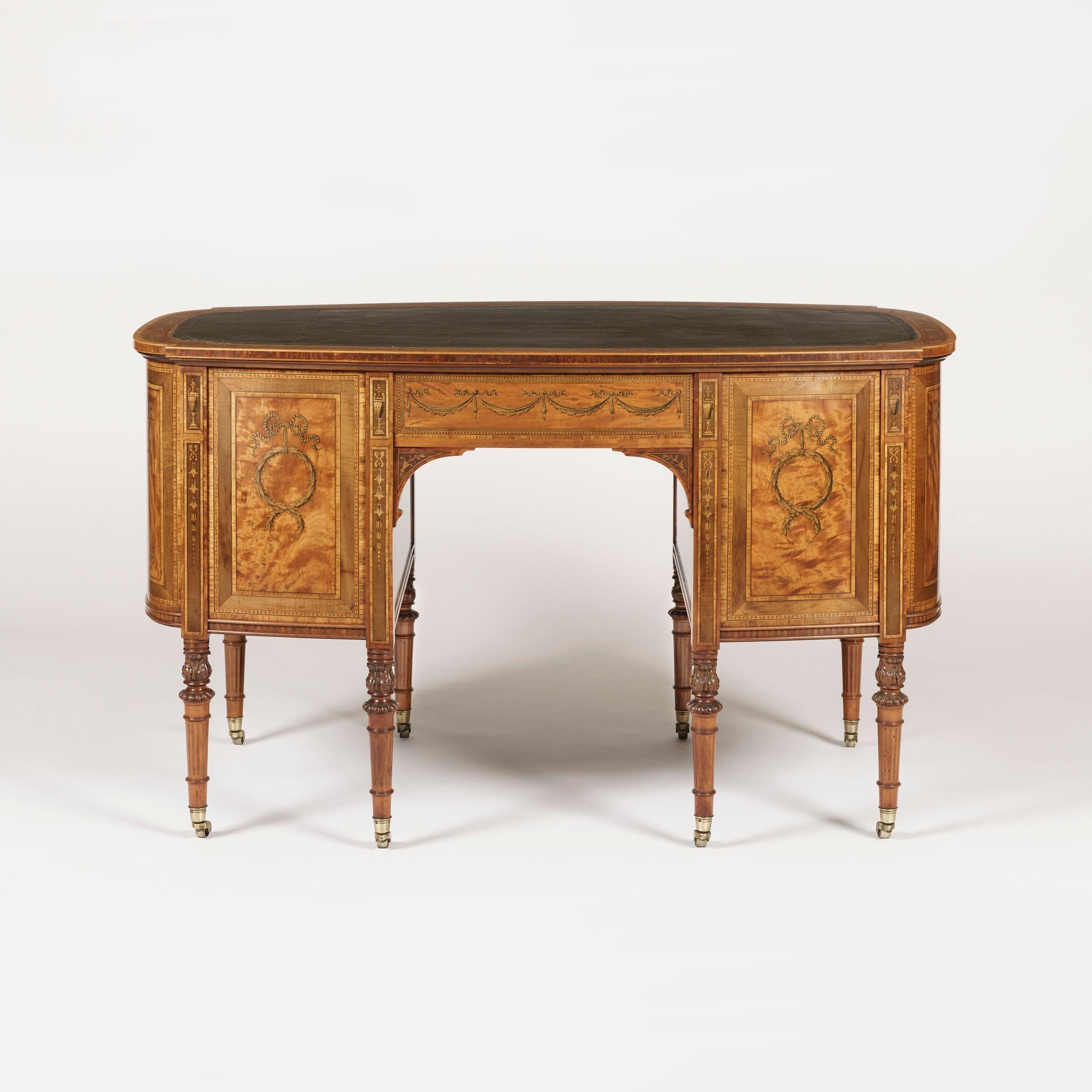 A library table in the adam manner almost certainly by Maple & Company

Constructed in a mellow patinated satinwood, with fine marquetry pictorial and foliate inlays utilising specimen woods including green stained sycamore; of shaped serpentine