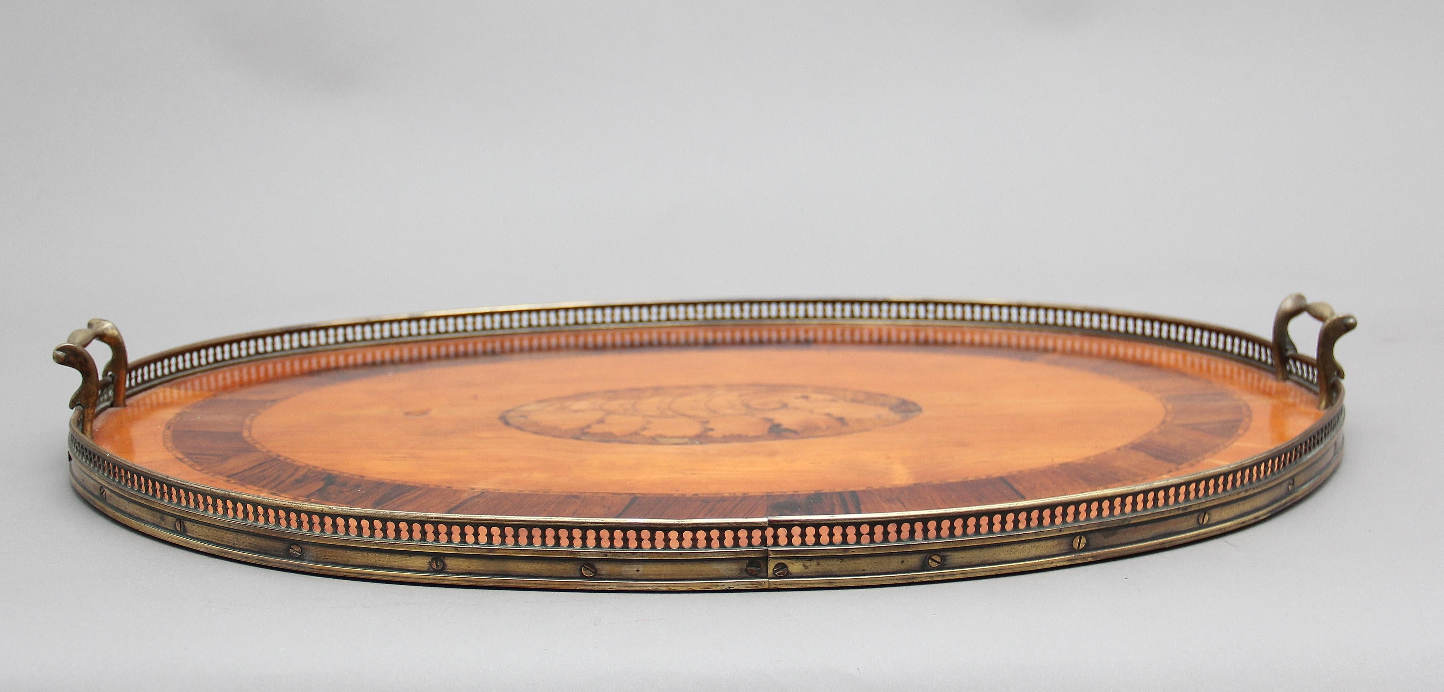 A decorative 19th century satinwood, brass and inlaid tray, the top crossbanded with inlaid shell decoration at the centre, having a pierced brass gallery running around the edge and brass carrying handles either end, circa 1880.
   